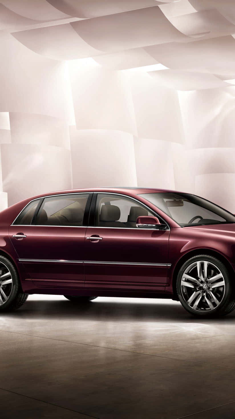 Volkswagen Phaeton 桌布 壁紙 — 一輛時尚的栗色轎車在柔和的工作室燈光下，映襯著帶有幾何陰影的雕刻白色牆壁，閃閃發光。