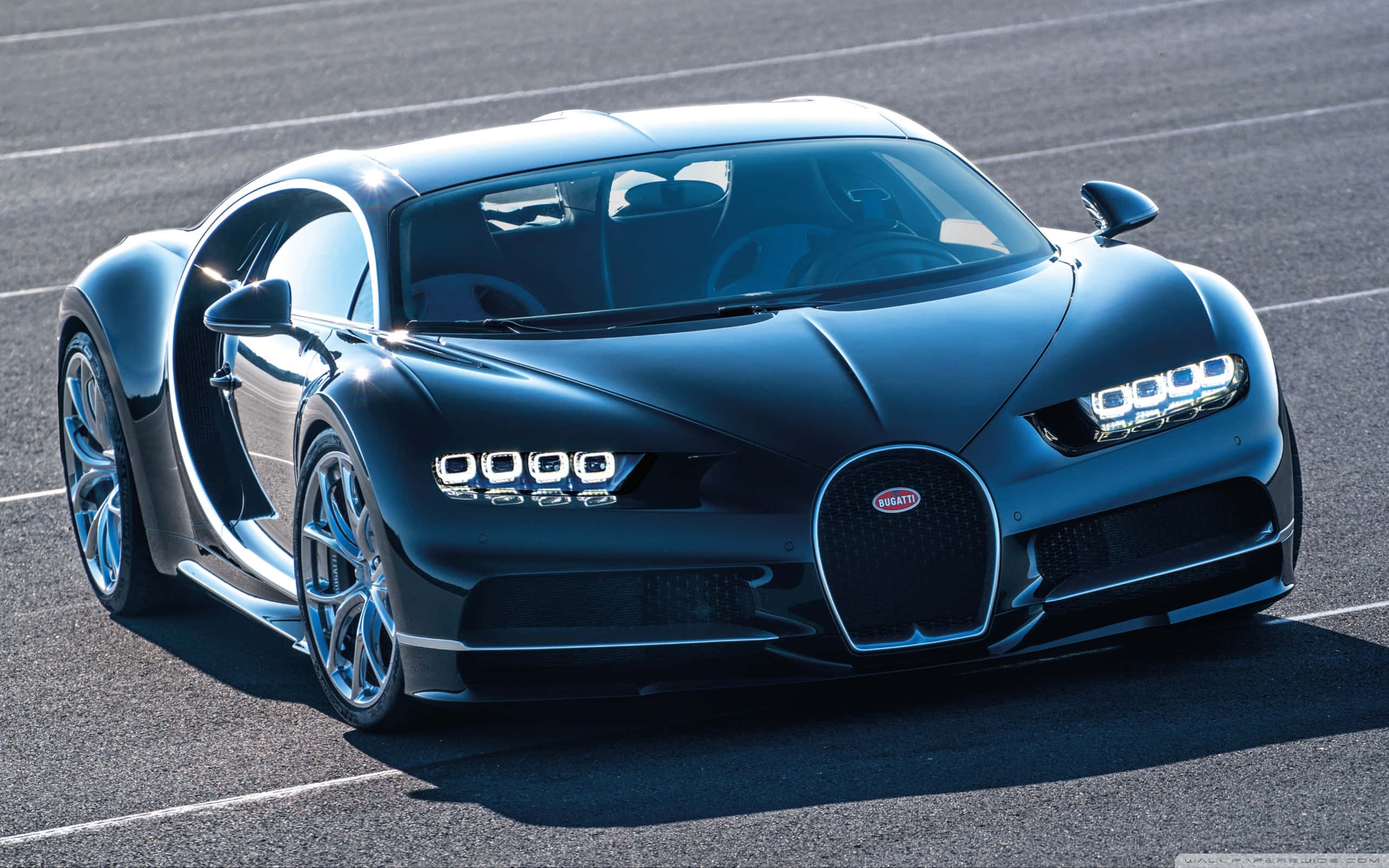 Bugatti Chiron 桌布 壁紙 — 一輛時尚的啞光黑色Bugatti Chiron跑車停在陽光明媚的瀝青賽道上，車門敞開。