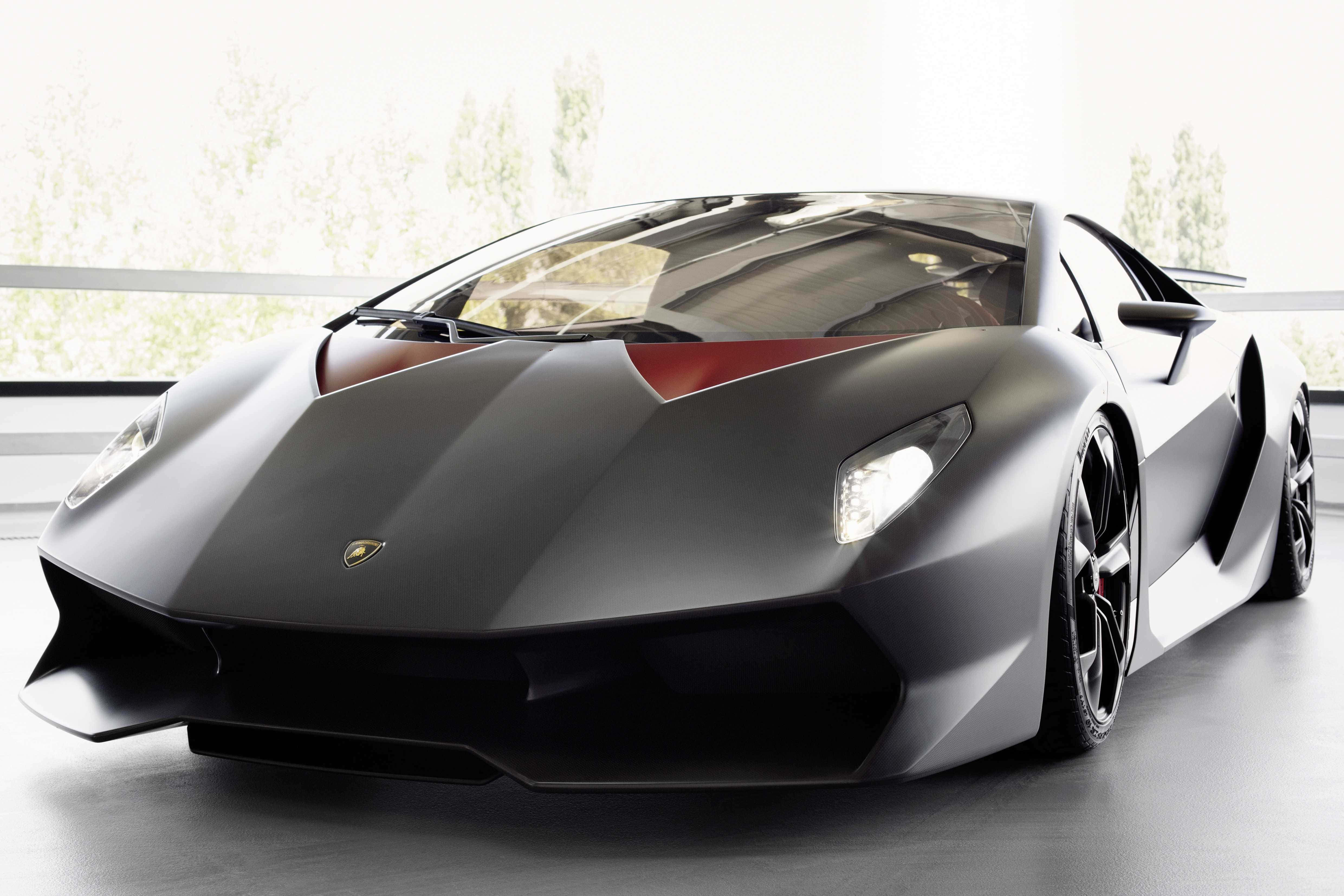Lamborghini Sesto Elemento 桌布 壁紙 — 一輛時尚的啞光黑色藍寶堅尼跑車帶有紅色點綴，在一個明亮現代、有大窗戶的工作室中展示。