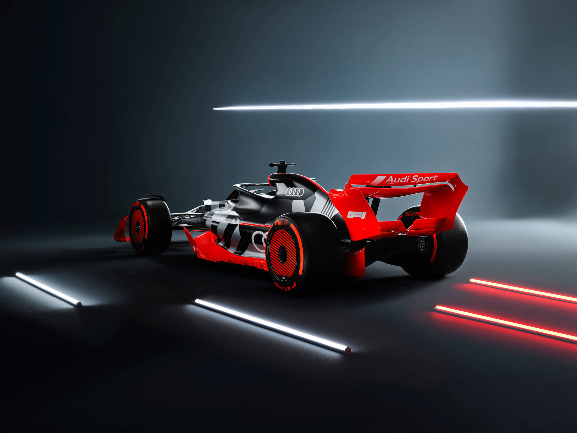 在黑暗的攝影棚中，霓虹燈照亮了紅黑 Audi 賽車。 — 酷炫F1 壁紙