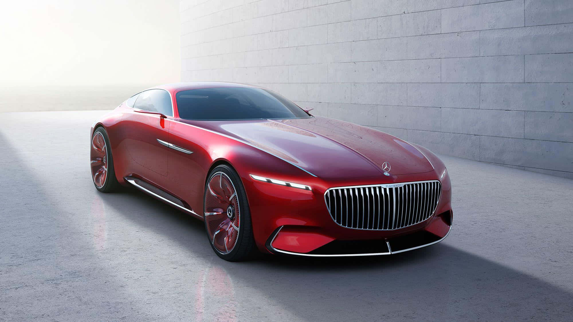 Maybach 桌布 壁紙 — 一輛時尚的紅色豪華跑車，帶有鍍鉻格柵和發光頭燈，停在簡約的混凝土牆前。