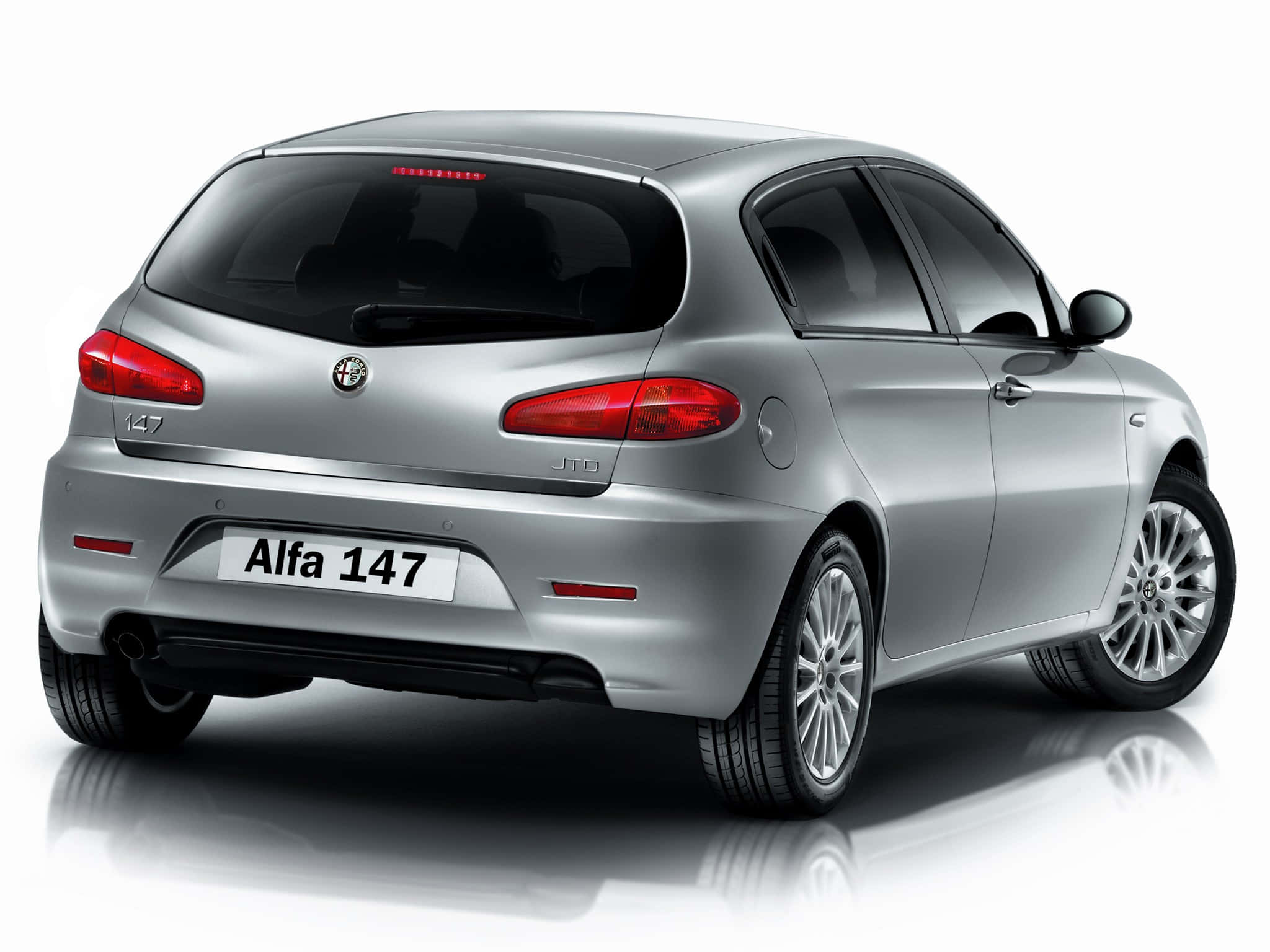 Alfa Romeo 147 桌布 壁紙 — 一輛流線型銀色Alfa 147掀背車，從後方四分之三角度展示，背景為潔白工作室，帶有微妙反射。
