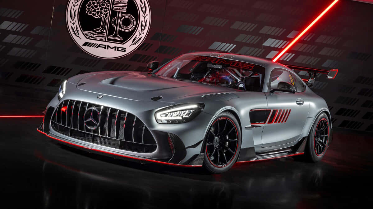 Mercedes Benz Amg Gt 桌布 壁紙 — 一輛時尚的銀色AMG GT賽車帶有紅色點綴，在戲劇性的紅色燈光下，以深色幾何背景展示。