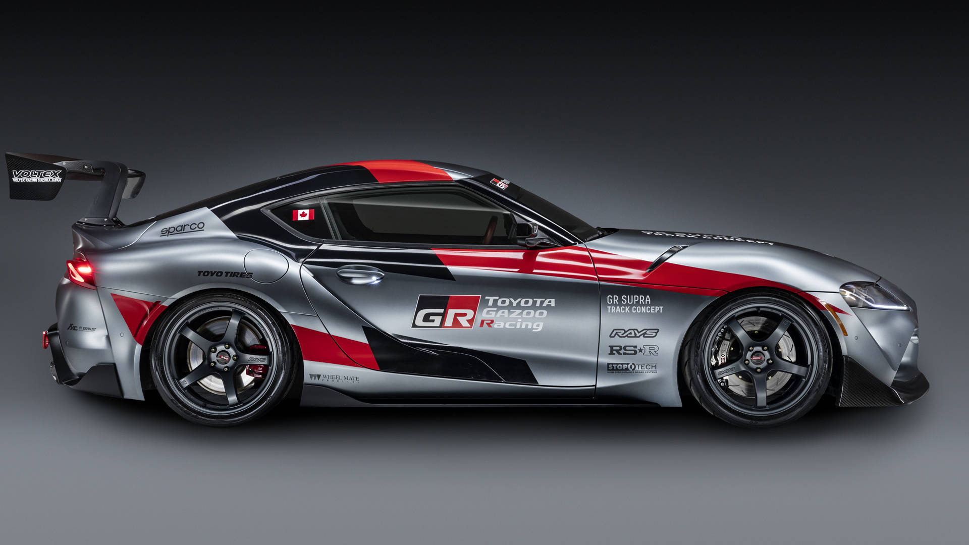 銀紅雙色豐田GR Supra賽車概念車，帶有黑色飾邊和贊助商貼紙。 — Toyota Supra 壁紙