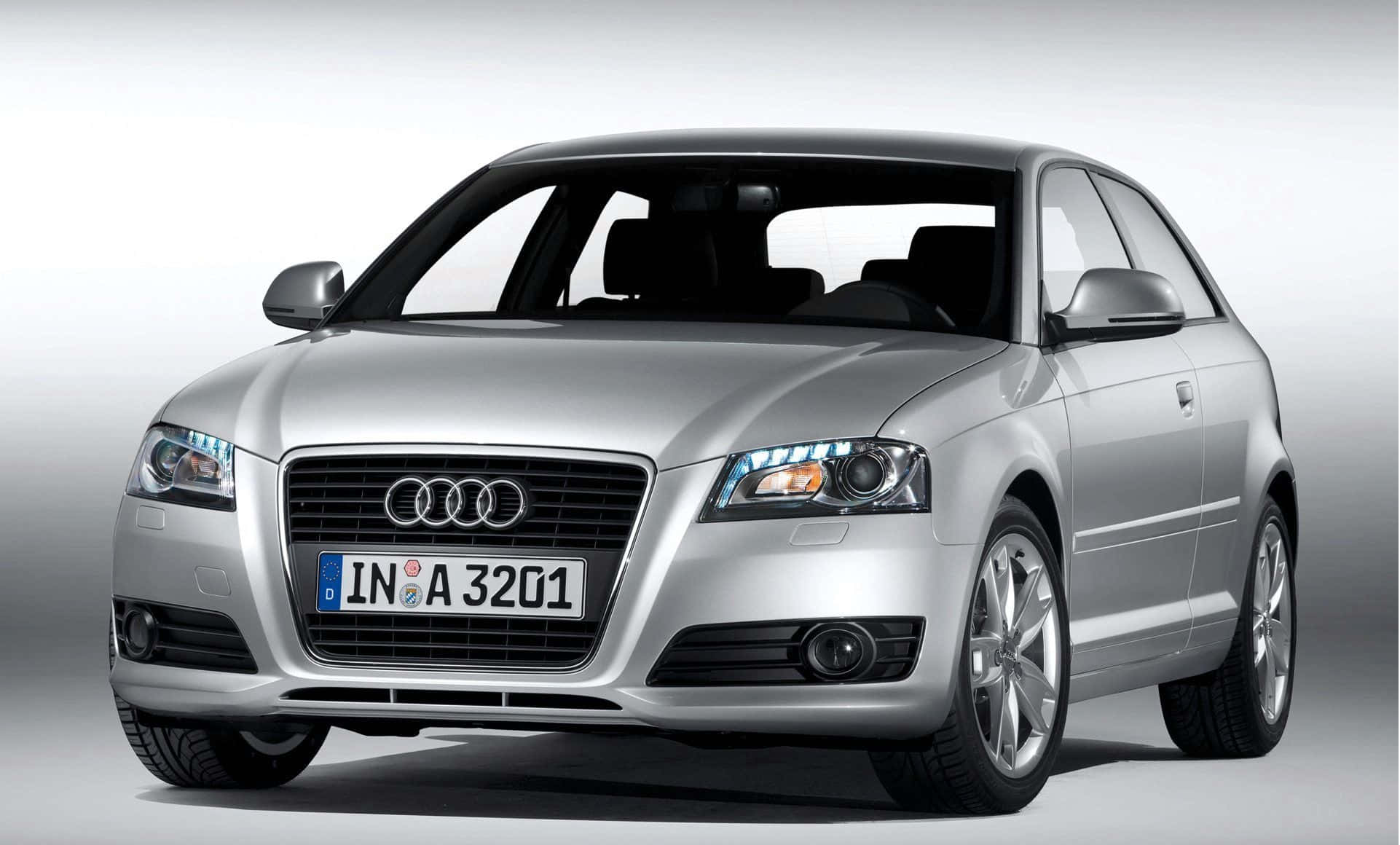 Audi S3 桌布 壁紙 — 一輛時尚的銀色奧迪A3雙門轎跑車在攝影棚內展示，配有柔和燈光和漸變灰色背景。