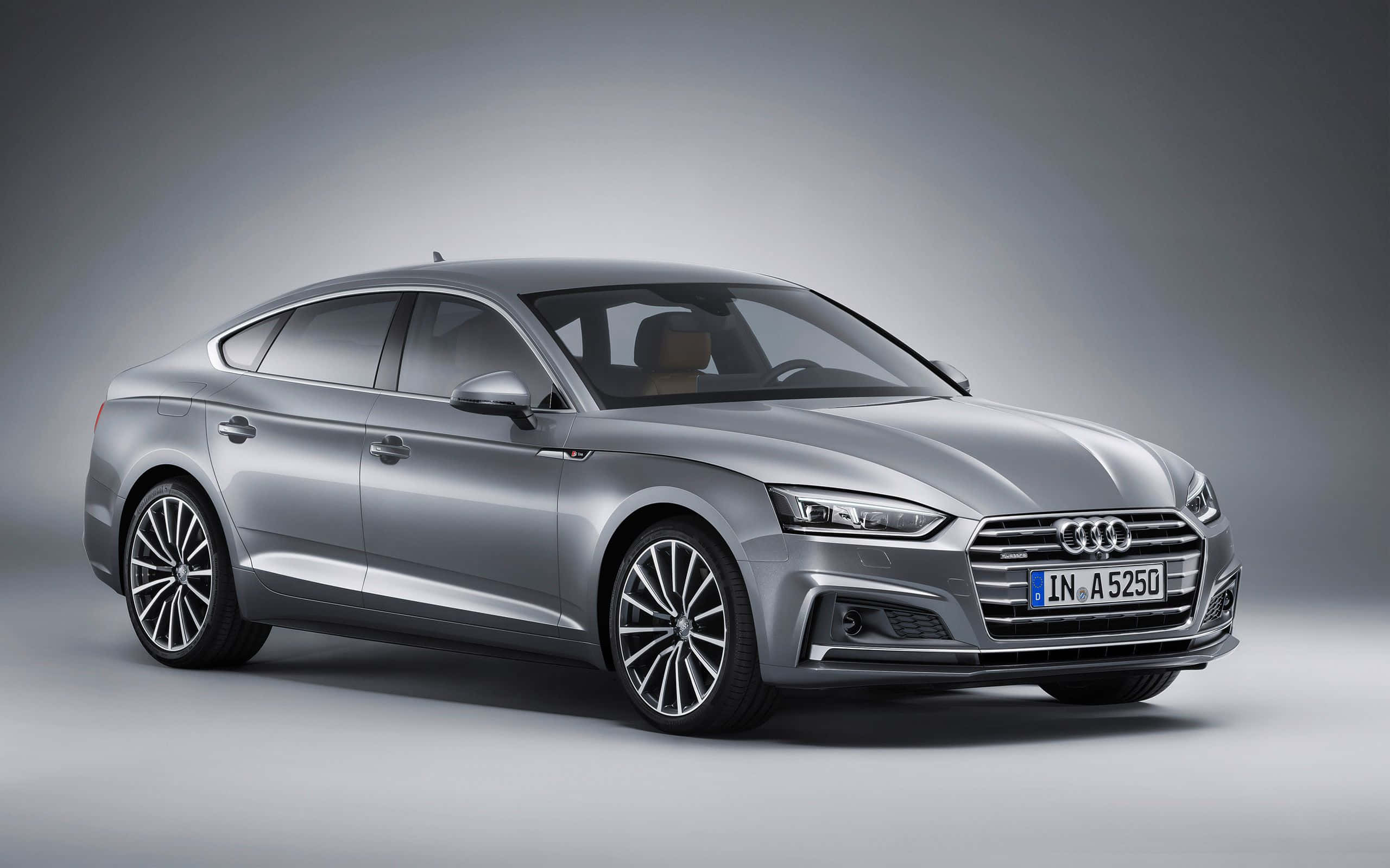 Audi A5 桌布 壁紙 — 一輛時尚的銀色奧迪A5 Sportback在簡約灰色背景的攝影棚燈光下閃閃發光。