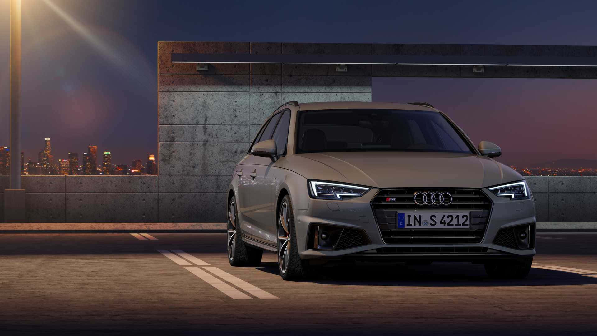 Audi S4 桌布 壁紙 — 一架時尚的銀色奧迪S4旅行車在黃昏時停泊在天台上，混凝土牆後是閃爍的城市天際線。