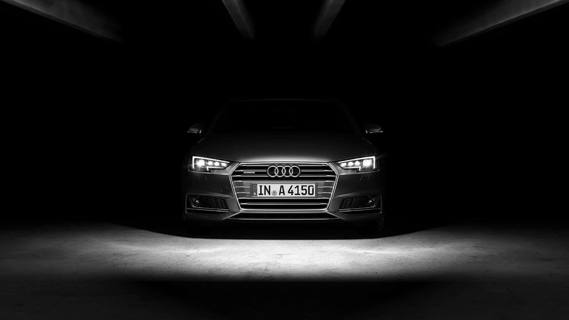 Audi A4 桌布 壁紙 — 一輛時尚的銀色奧迪轎車在黑暗隧道中被聚光燈照亮，呈現戲劇性的高對比度。