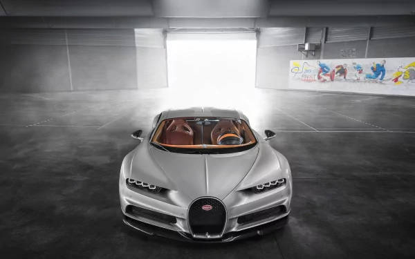 銀色Bugatti Chiron在現代工業風車庫中，帶有強烈背光。 — 4K 壁紙