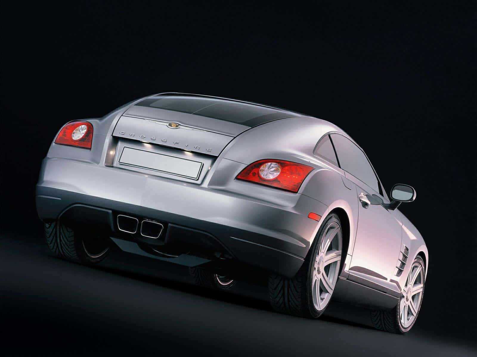 Chrysler Crossfire 桌布 壁紙 — 一輛時尚的銀色 Chrysler Crossfire 跑車，從後方四分之三角度展示，背景為深色攝影棚。