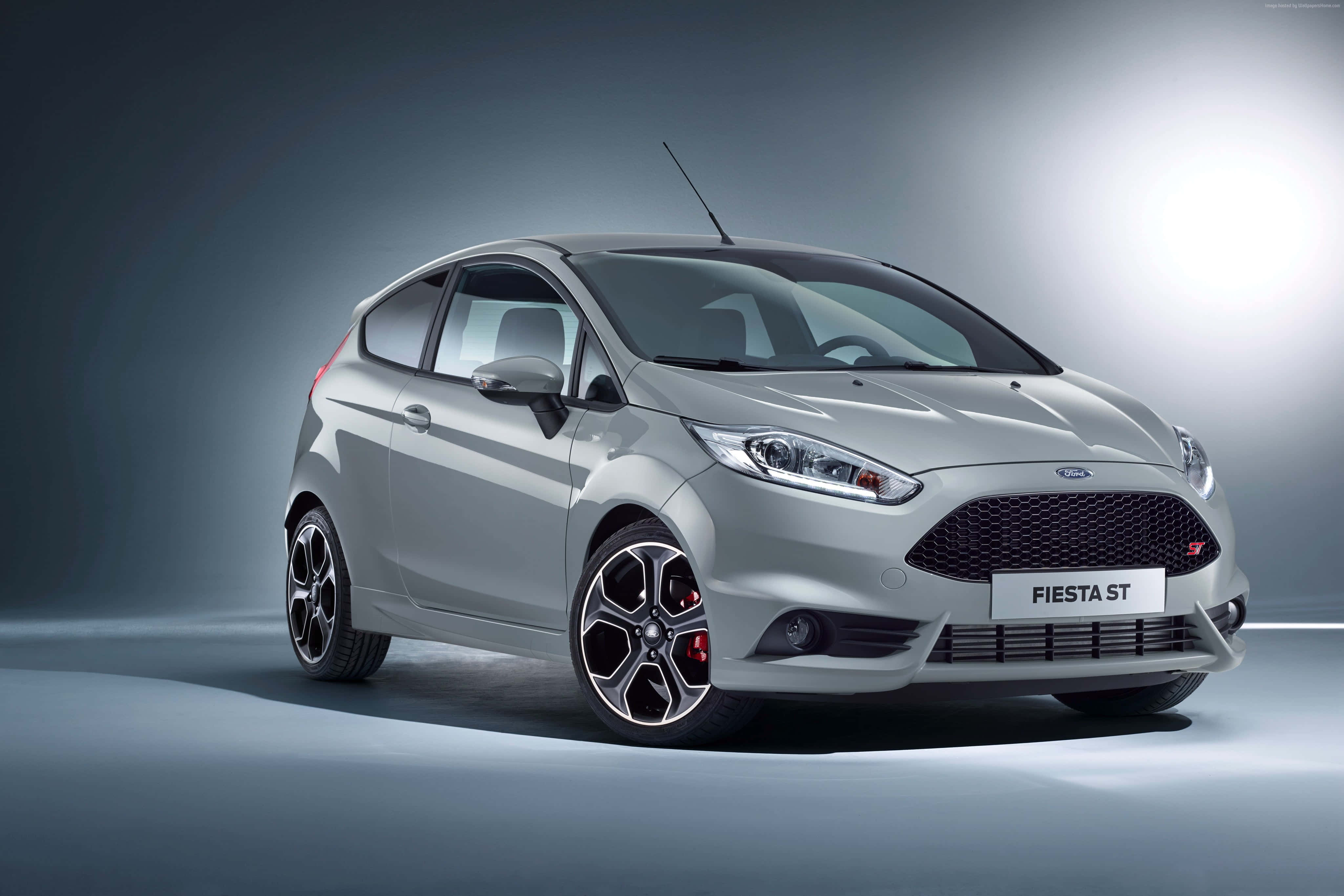 Ford Fiesta 桌布 壁紙 — 一輛時尚的銀色福特 Fiesta ST 跑車在工作室中展示，配有戲劇性的燈光和漸變灰色背景。