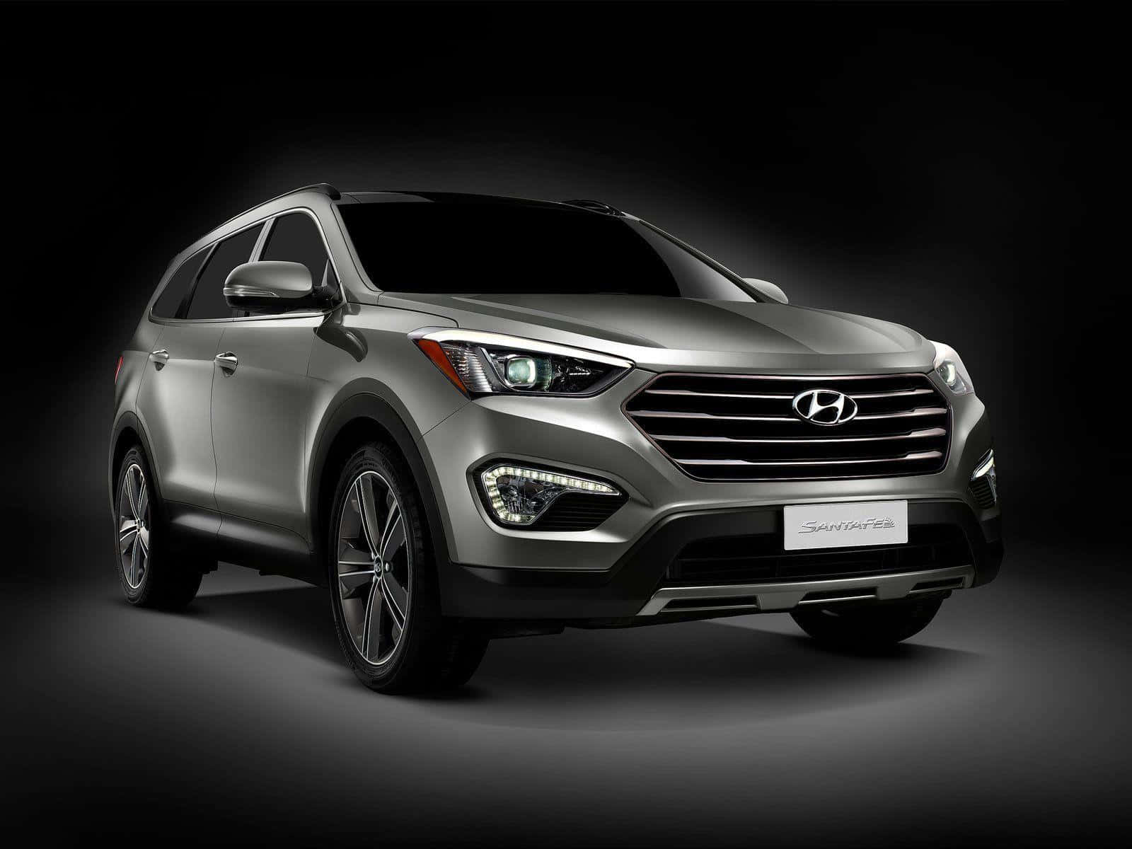 Hyundai Santa Fe 桌布 壁紙 — 一部時尚的銀色現代Santa Fe SUV在黑暗背景的聚光燈下以戲劇性的攝影棚照片展示。