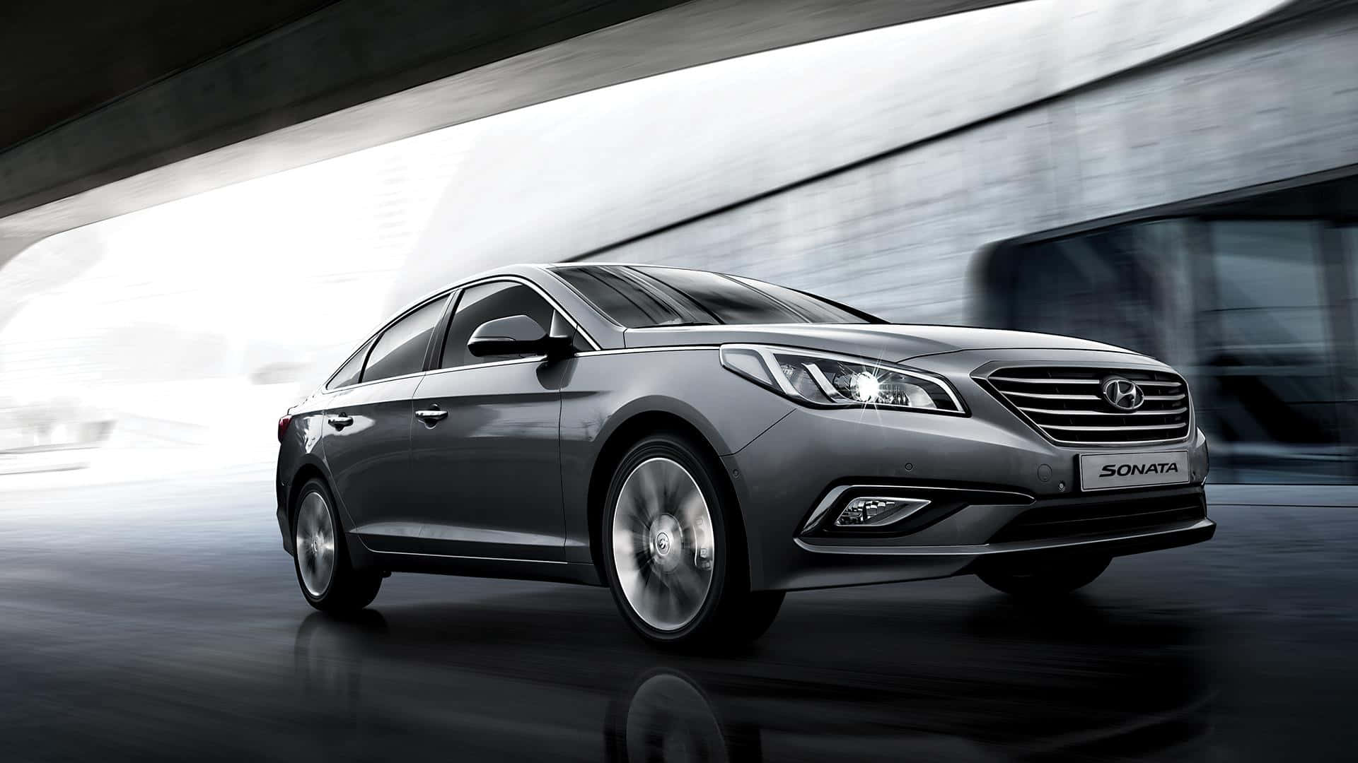Hyundai Sonata 桌布 壁紙 — 一輛時尚的銀色現代Sonata在現代混凝土天橋下行駛，背景帶有動態模糊效果。