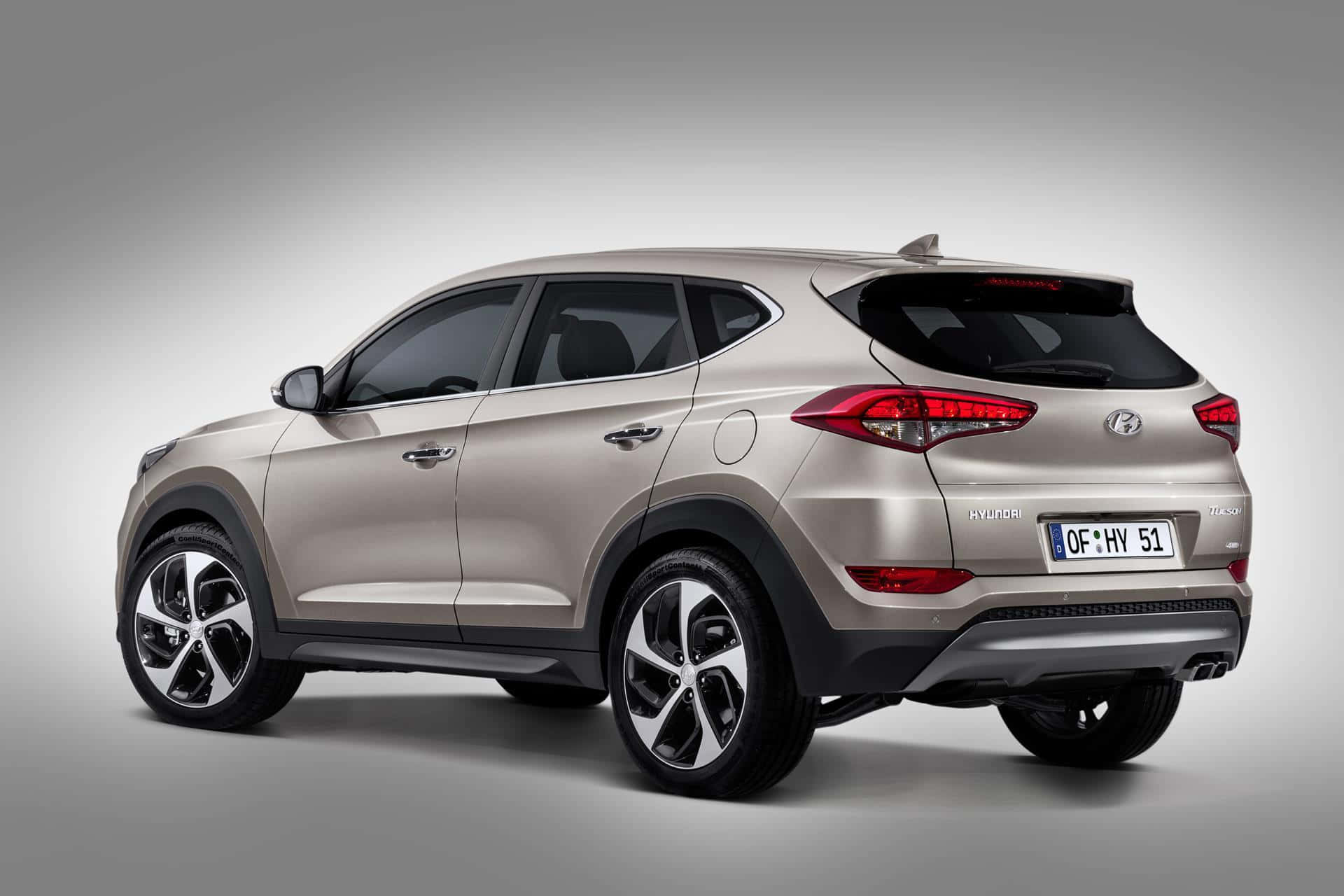Hyundai Tucson 桌布 壁紙 — 一輛時尚的銀色Hyundai Tucson SUV在攝影棚拍攝中，以背面四分之三角度呈現，背景為中性灰色。