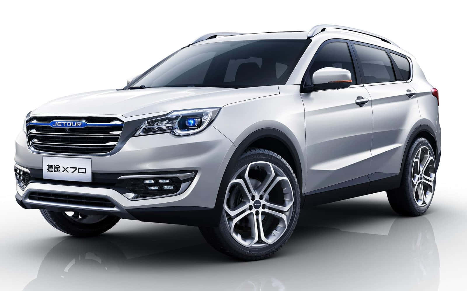 Chery A3 桌布 壁紙 — 一輛時尚的銀色Jetour X70 SUV，配備藍色飾邊頭燈和合金輪圈，在乾淨的攝影棚環境中展示，地板具有反射效果。