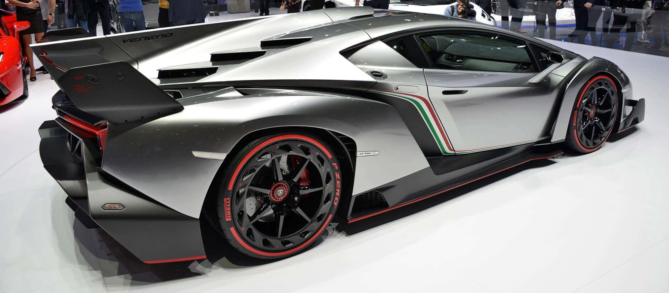 Lamborghini Veneno 桌布 壁紙 — 一輛時尚的銀色藍寶堅尼 Veneno，帶有紅色點綴和義大利國旗條紋，在車展上展出。