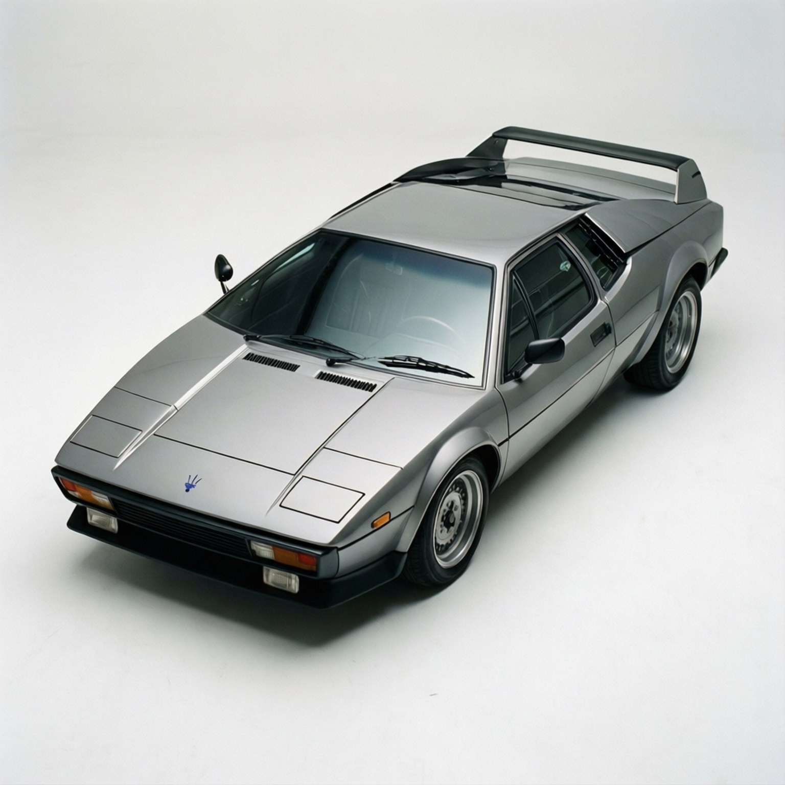 Maserati Bora 桌布 壁紙 — 一台時尚的銀色瑪莎拉蒂跑車，帶有黑色後擾流板，從高角度在純白色背景上拍攝。