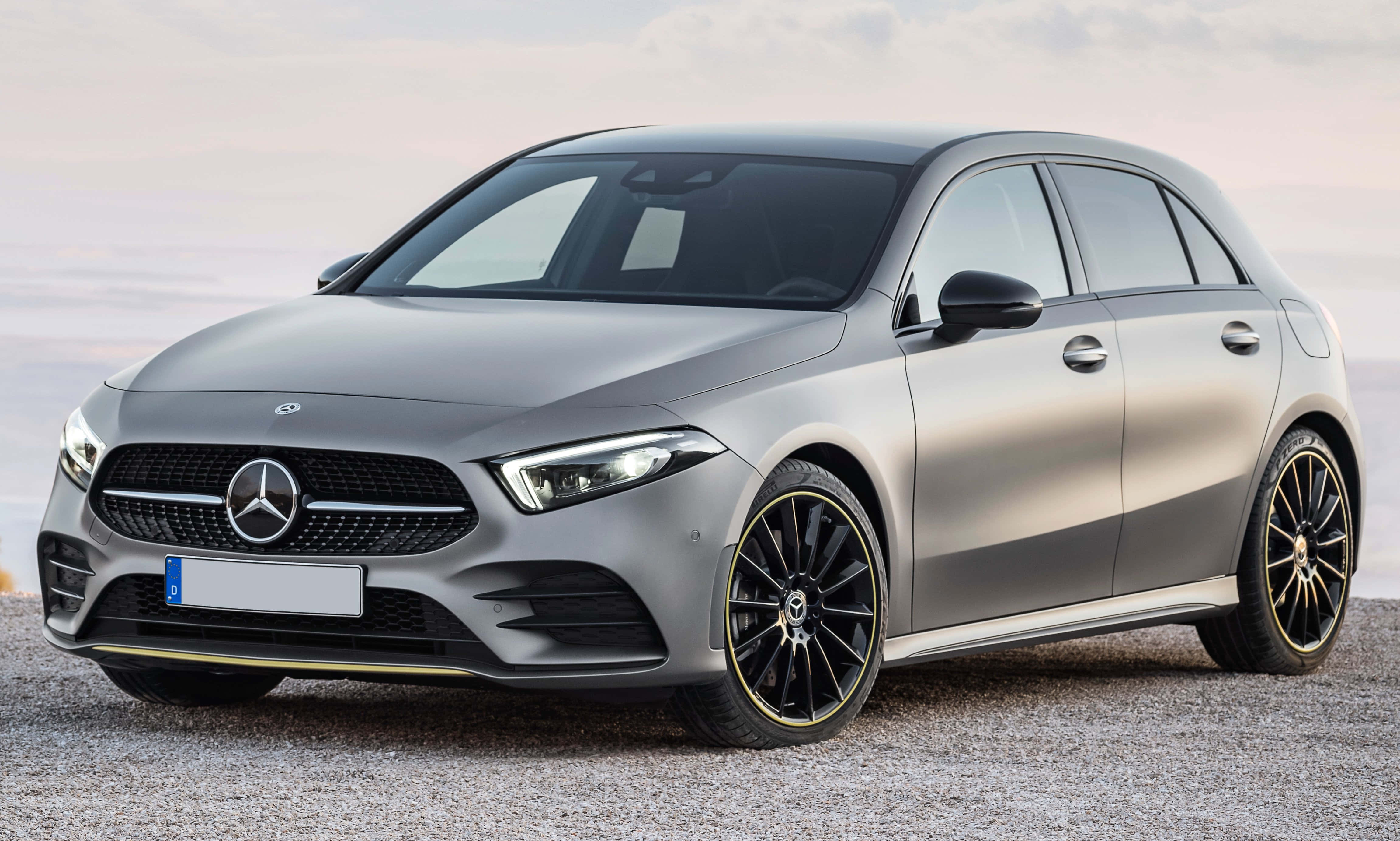 Mercedes Benz A-class 桌布 壁紙 — 一輛時尚的銀色 Mercedes-Benz A-Class 掀背車配黑色合金輪圈，在柔和暮色下停泊在碎石路面上。