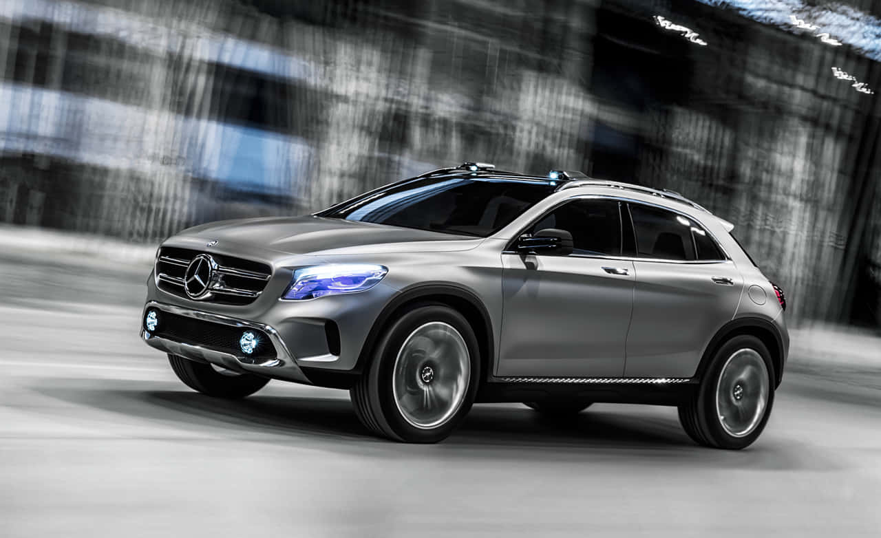 Mercedes Benz Gla-class 桌布 壁紙 — 一輛時尚的銀色賓士SUV在模糊的城市隧道中疾馳，藍色車頭燈閃爍發光。