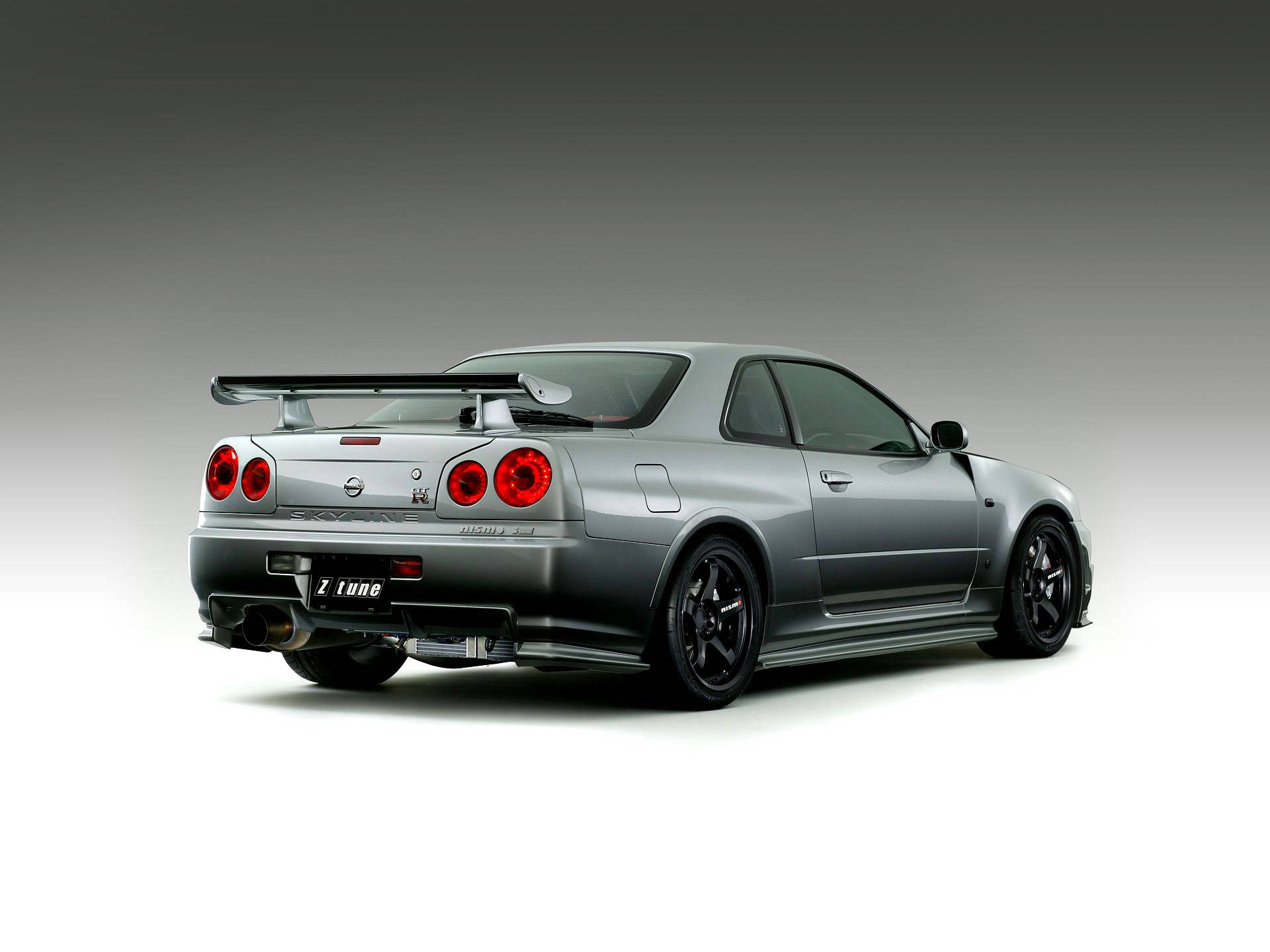 銀色日產Skyline GT-R，配備紅色尾燈和黑色輪圈，在工作室環境中。 — 城市天際線汽車 壁紙