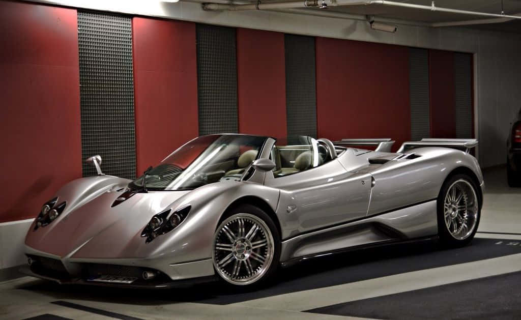 Pagani Zonda C12 Roadster 桌布 壁紙 — 一輛時尚的銀色Pagani Zonda Roadster敞篷跑車停放在現代車庫中，車庫有紅色和灰色牆壁。