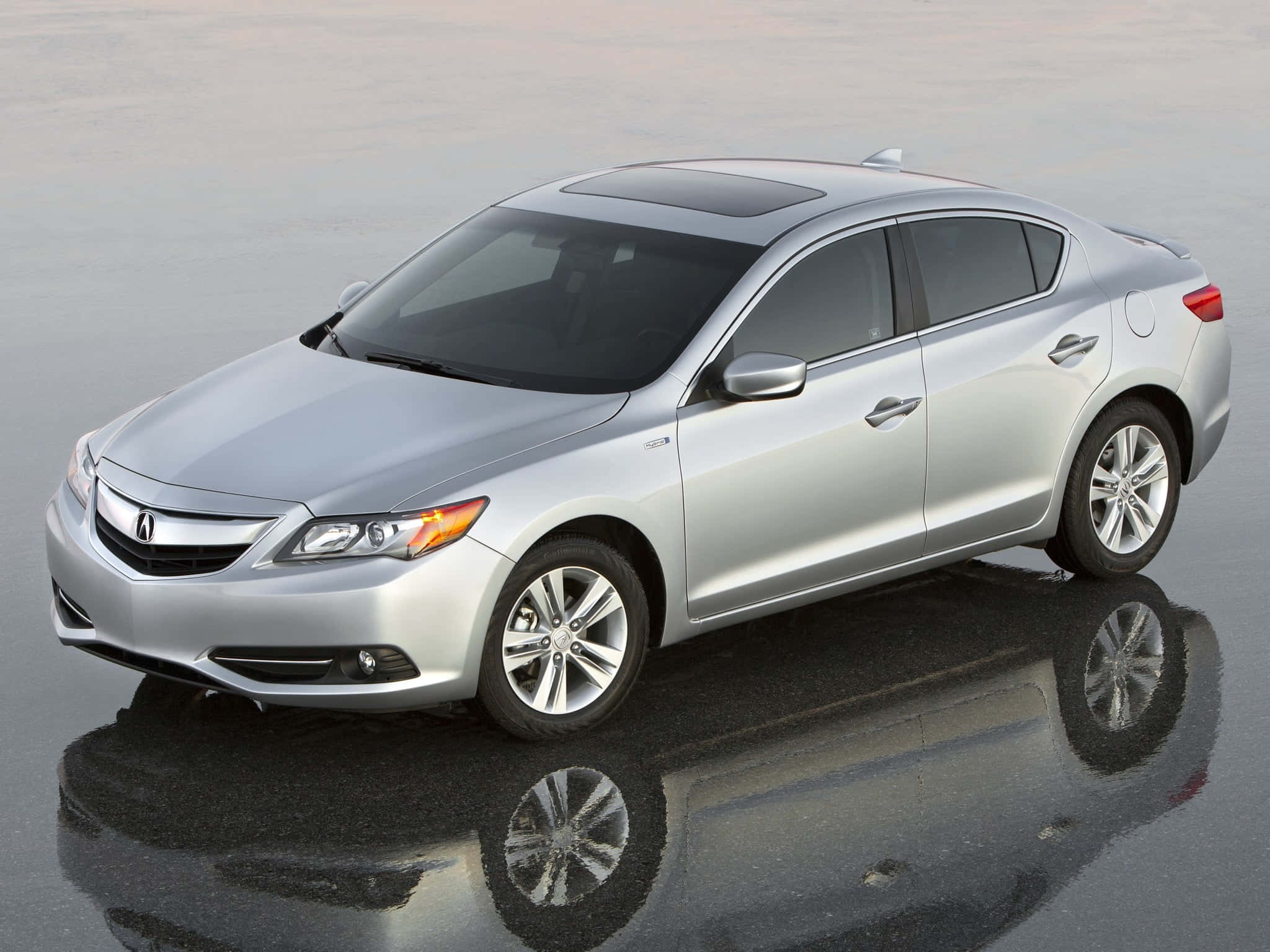Acura Ilx 桌布 壁紙 — 一輛時尚的銀色轎車在柔和日光下完美倒映在濕漉漉的路面上。