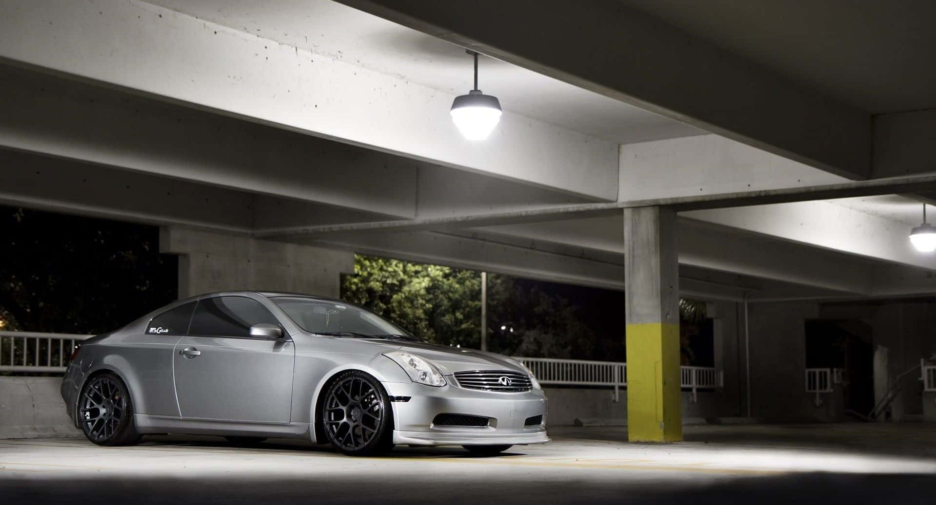 Infiniti G35 桌布 壁紙 — 一輛時尚的銀色跑車在夜間停放在混凝土天橋下，由單個吊燈照亮。