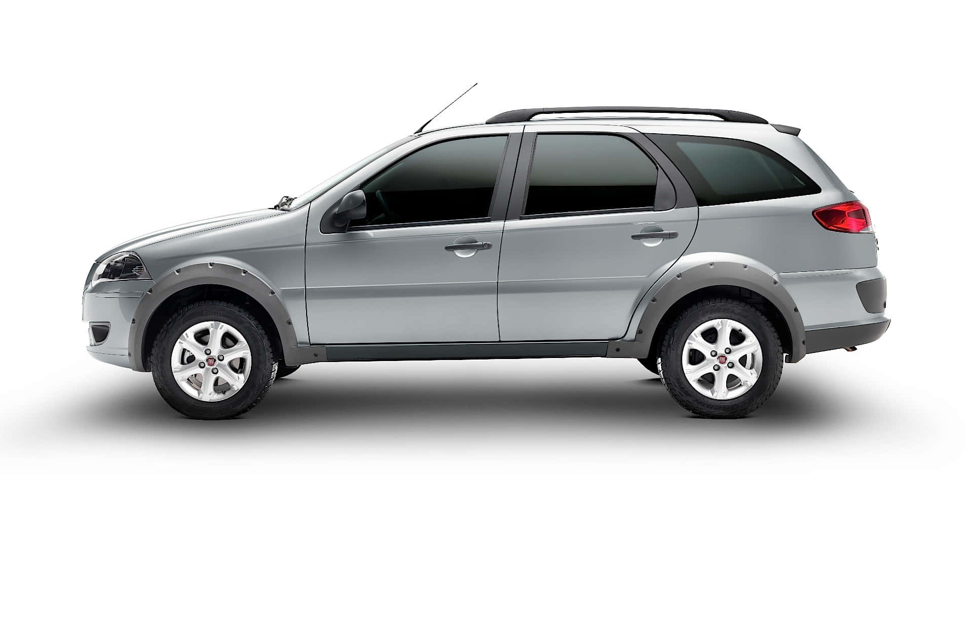 Fiat Palio 桌布 壁紙 — 一輛時尚的銀色旅行車，帶有黑色飾邊和車頂行李架，孤立地矗立在純白色背景上。