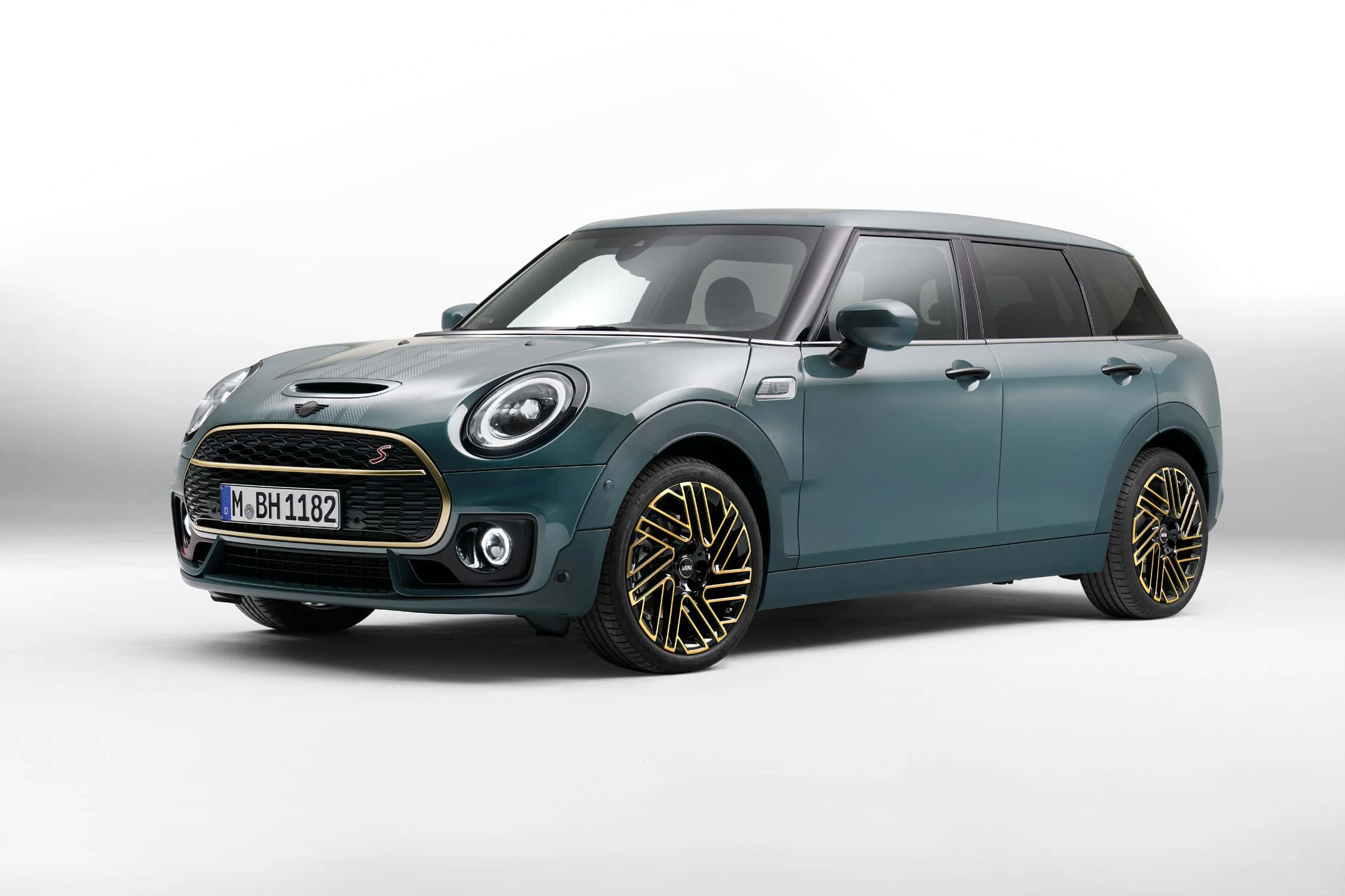Mini Cooper S Clubman All4 桌布 壁紙 — 一輛時尚的青綠色MINI Cooper S，配以金色輪圈，在簡約的白色工作室背景下蓄勢待發。