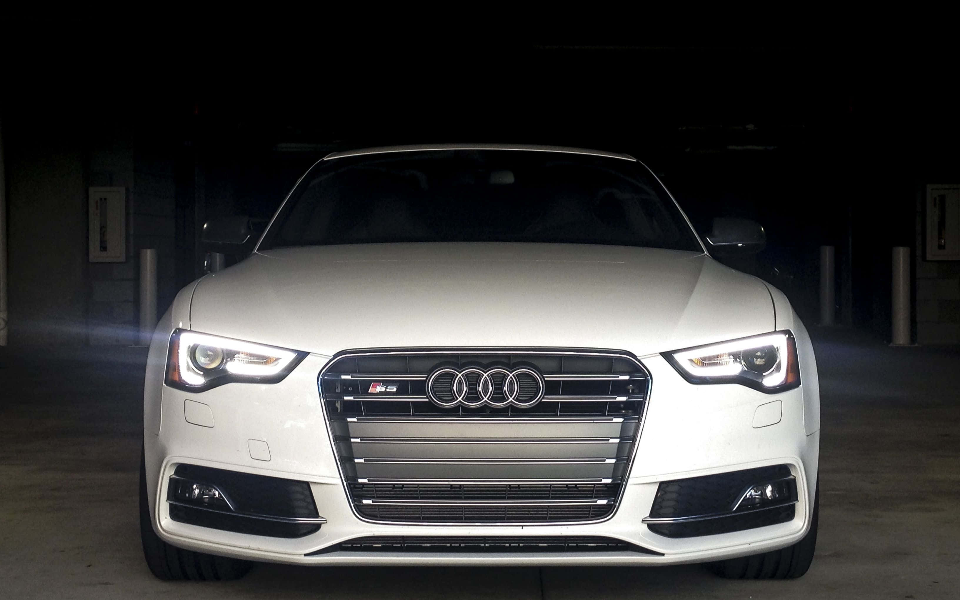 Audi S6 桌布 壁紙 — 一輛時尚的白色奧迪S5跑車在黑暗的地下停車場中，在戲劇性的聚光燈下閃耀。