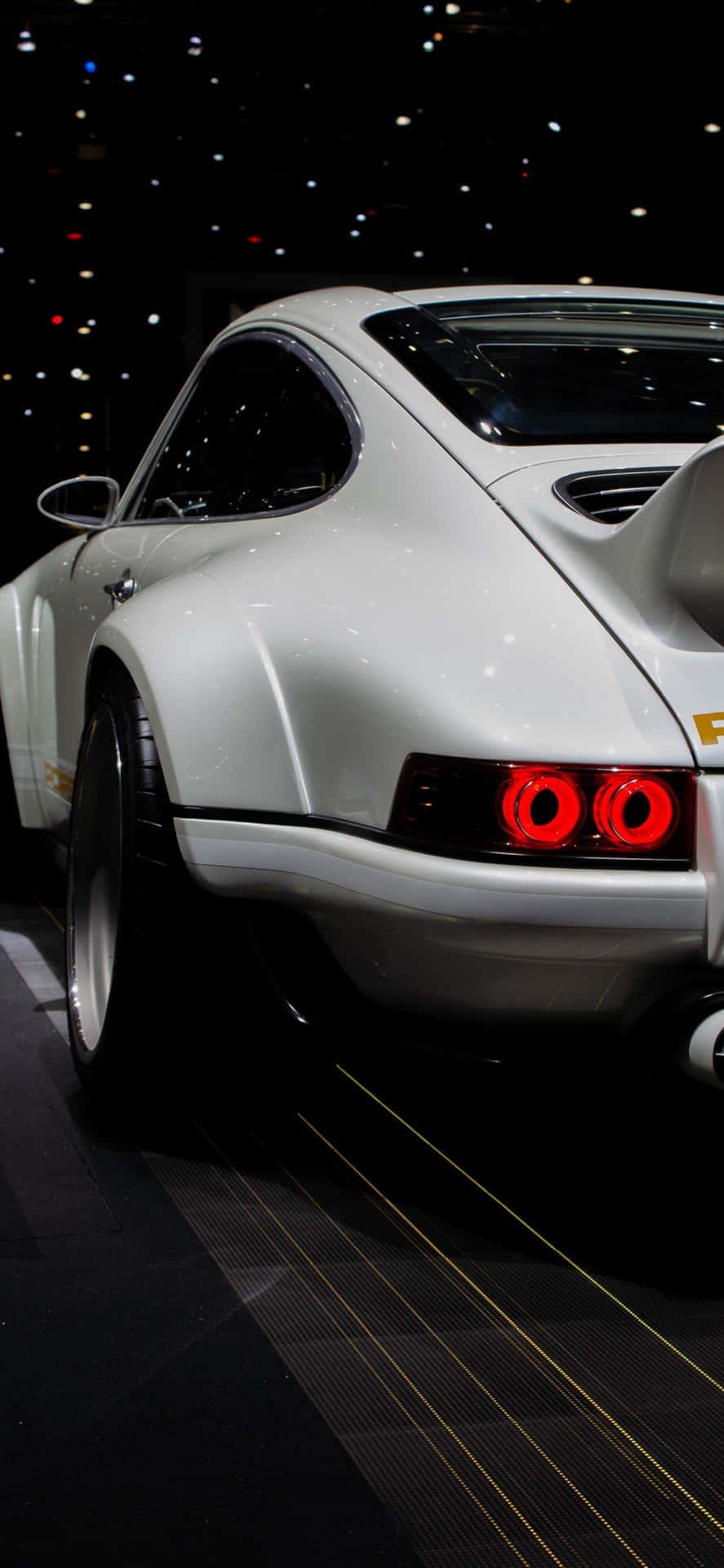 在黑暗展廳中展示的白色經典跑車，帶有紅色尾燈。 — Project Cars 2 壁紙
