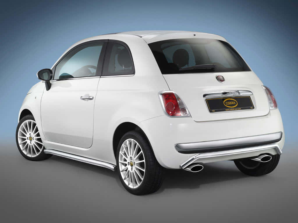 Fiat 500 桌布 壁紙 — 一輛時尚的白色Fiat 500，配備定制Cobra徽章和雙排氣管，在工作室燈光下展示。