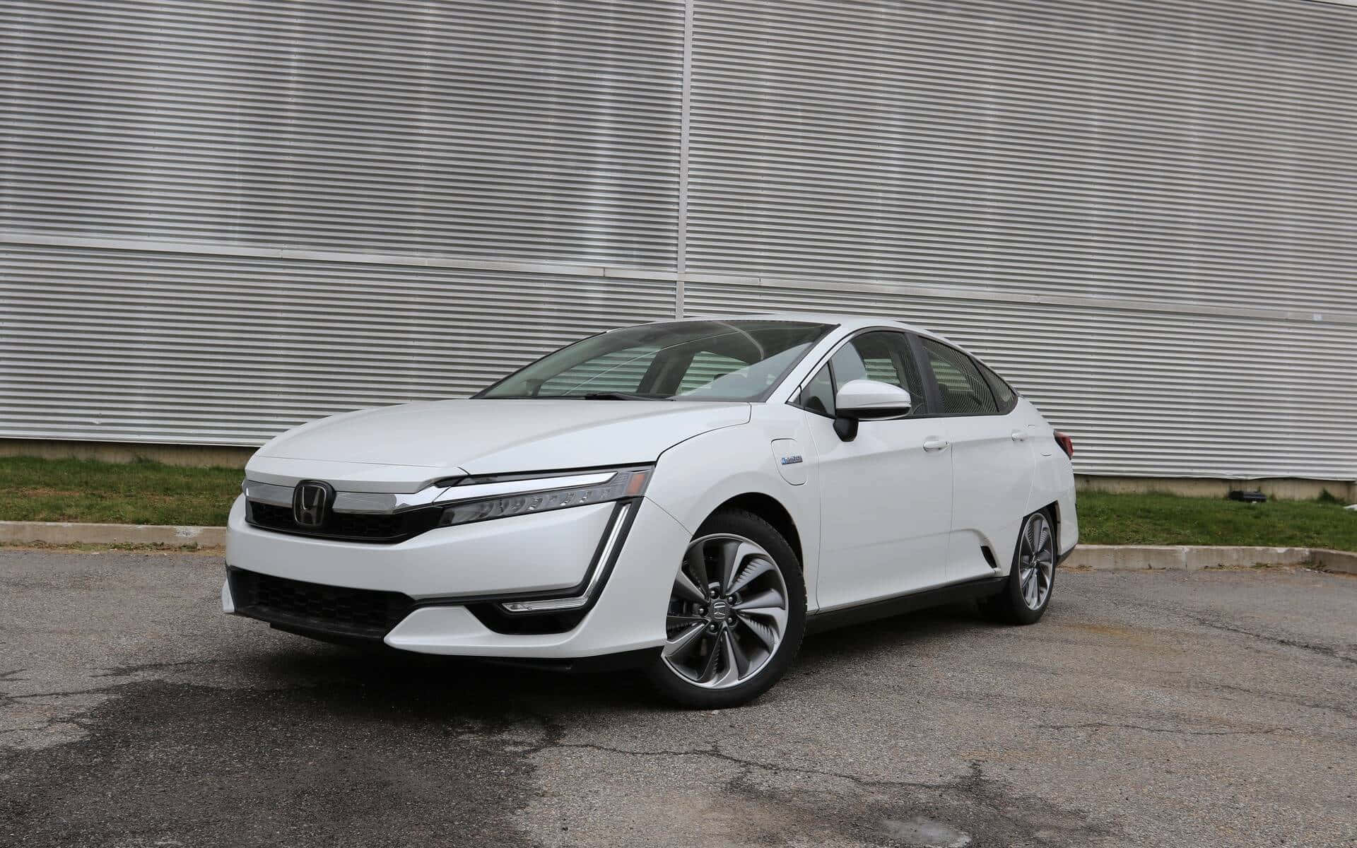 Honda Clarity 桌布 壁紙 — 一輛時尚的白色本田電動轎車停在柏油路上，前面是波紋金屬牆。
