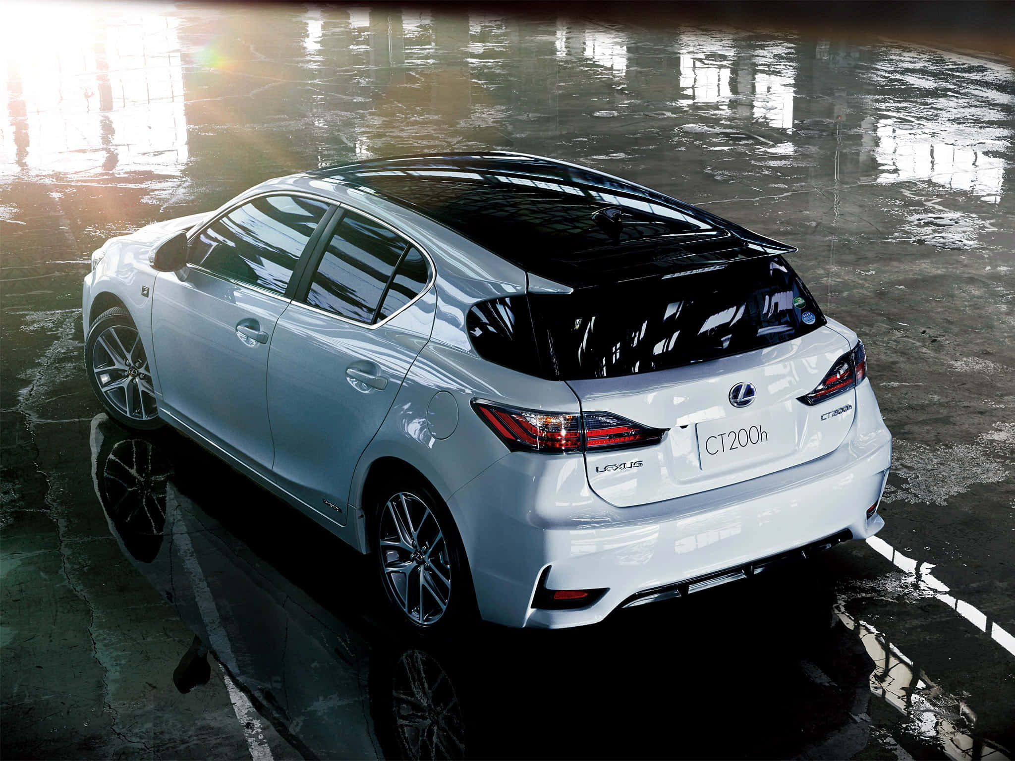 Lexus Ct 200h 桌布 壁紙 — 一輛時尚的白色Lexus CT200h房車在寬敞車庫中，在明亮的頂燈下映照在濕混凝土上。