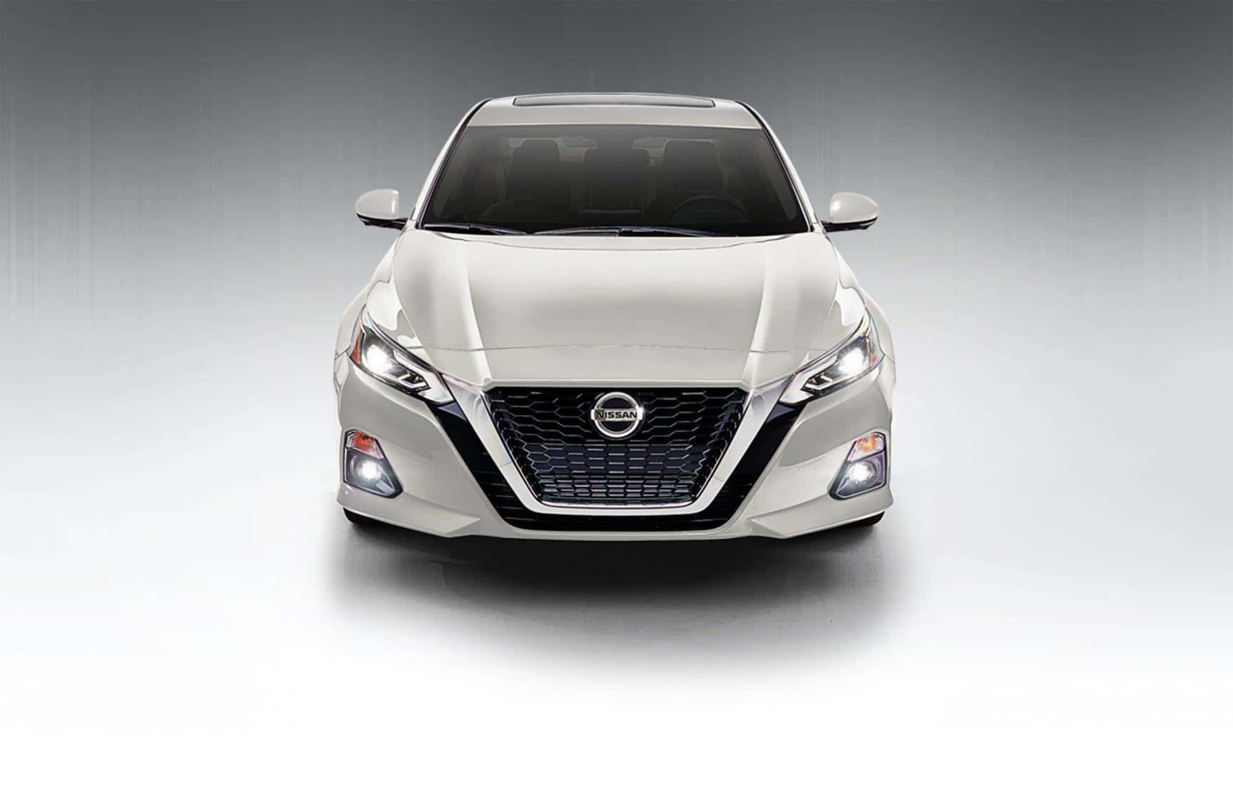 Nissan Altima 桌布 壁紙 — 一輛流線型白色日產轎車正面朝前，配備銳利頭燈和醒目水箱護罩，背景為漸層攝影棚背景。