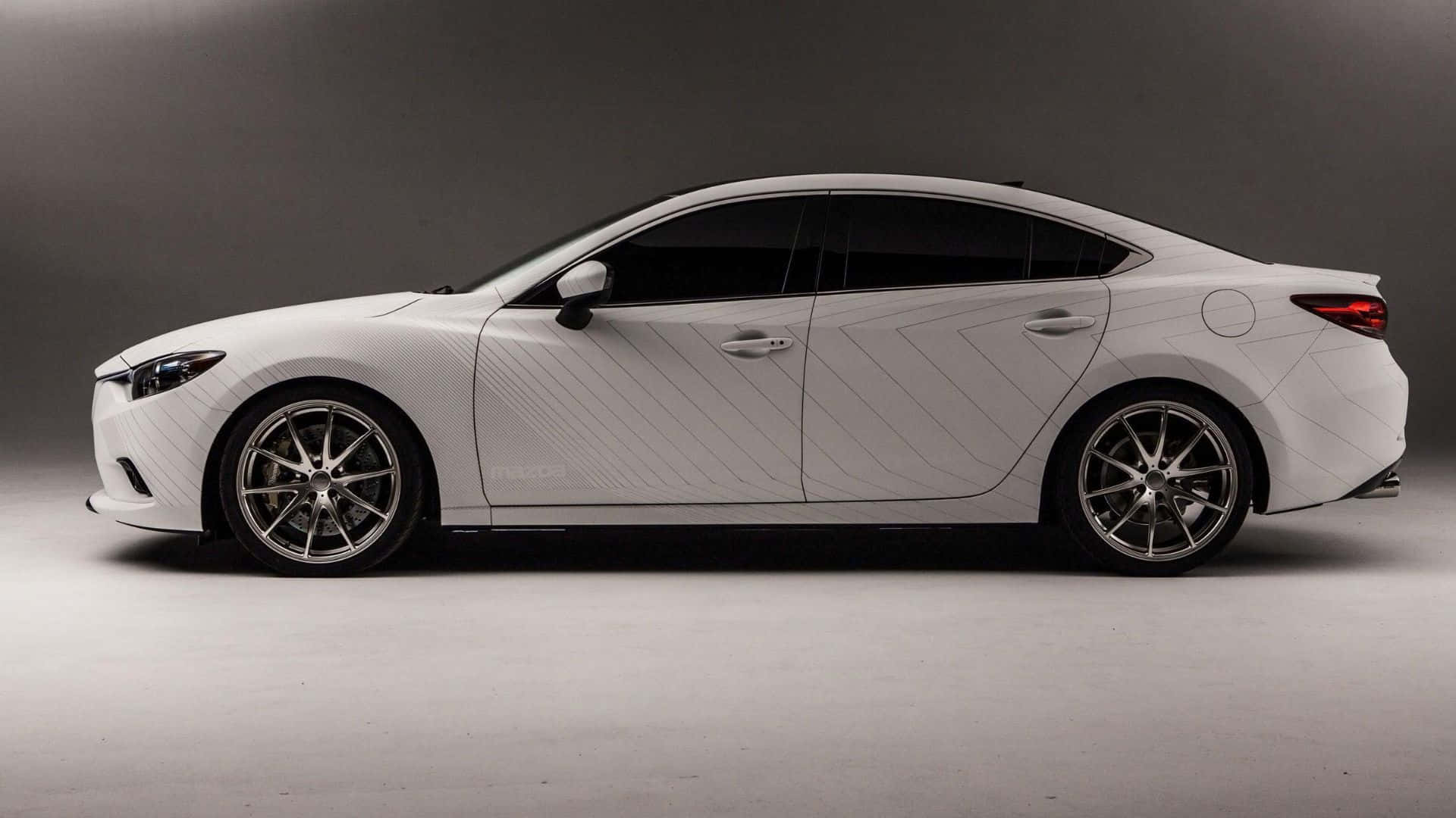 Mazda 6 桌布 壁紙 — 一輛時尚的白色轎車帶有對角線條貼花，在極簡灰色工作室背景中以側面展示。