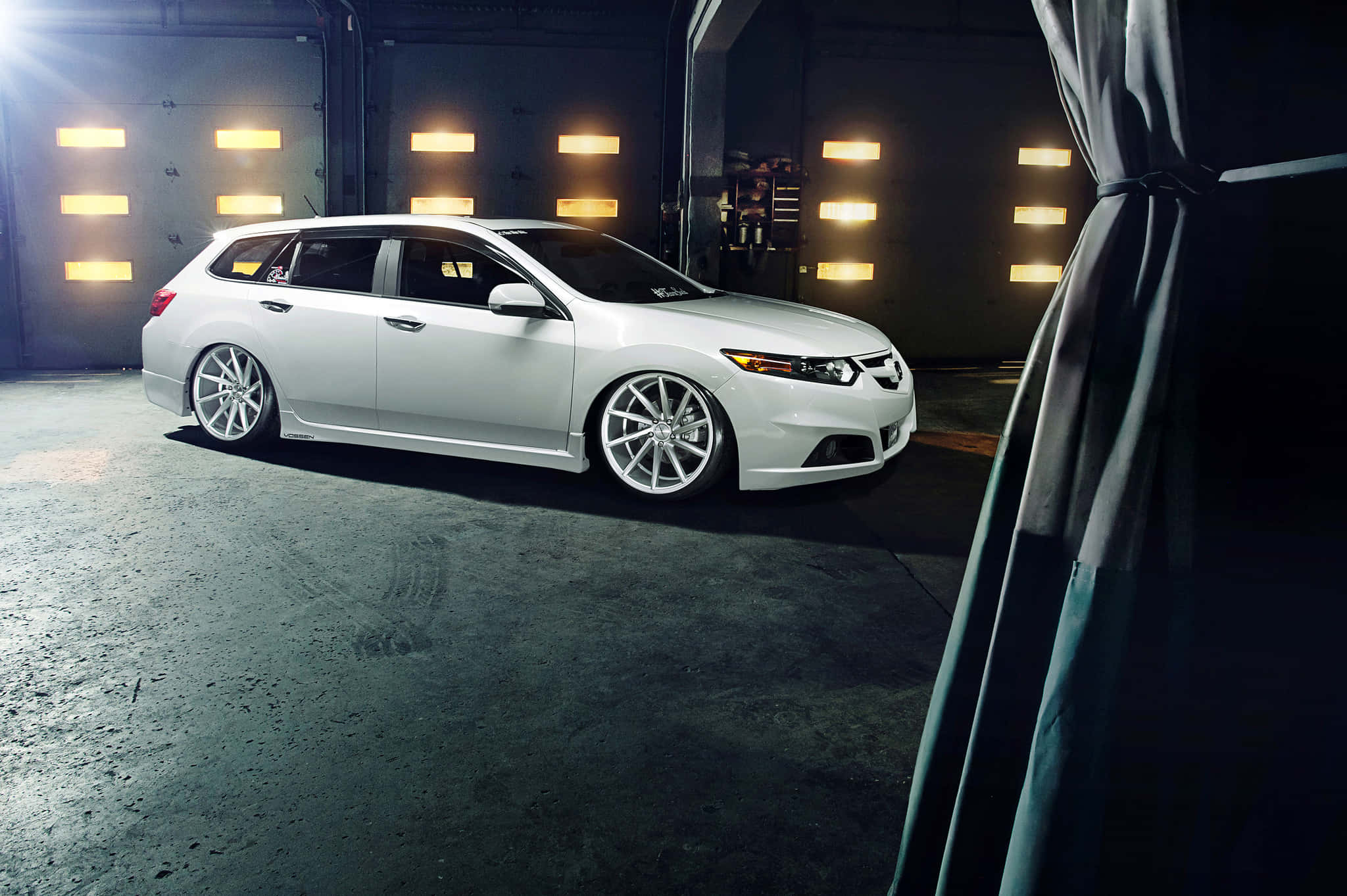 Acura Tsx 桌布 壁紙 — 一輛時尚的白色旅行車配備定制輪圈，在黑暗的車庫中被發光的牆板戲劇性地照亮。