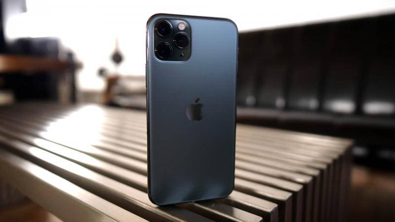 藍色 iPhone 12 Pro Max 站立在室內金屬長凳上。 — iPhone 11 壁紙
