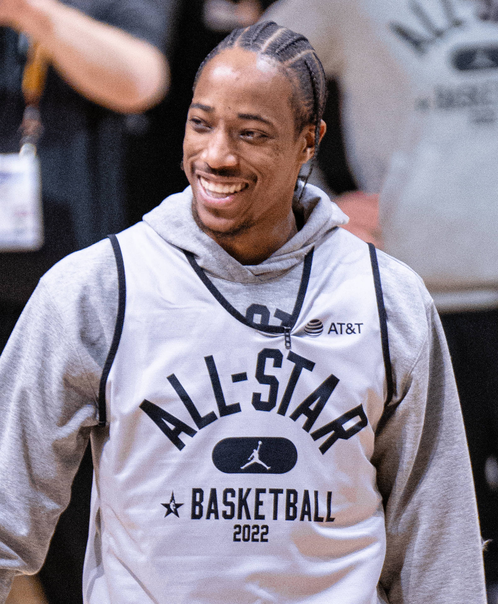 籃球運動員在場館活動中身穿All-Star 2022球衣微笑。 — NBA 壁紙