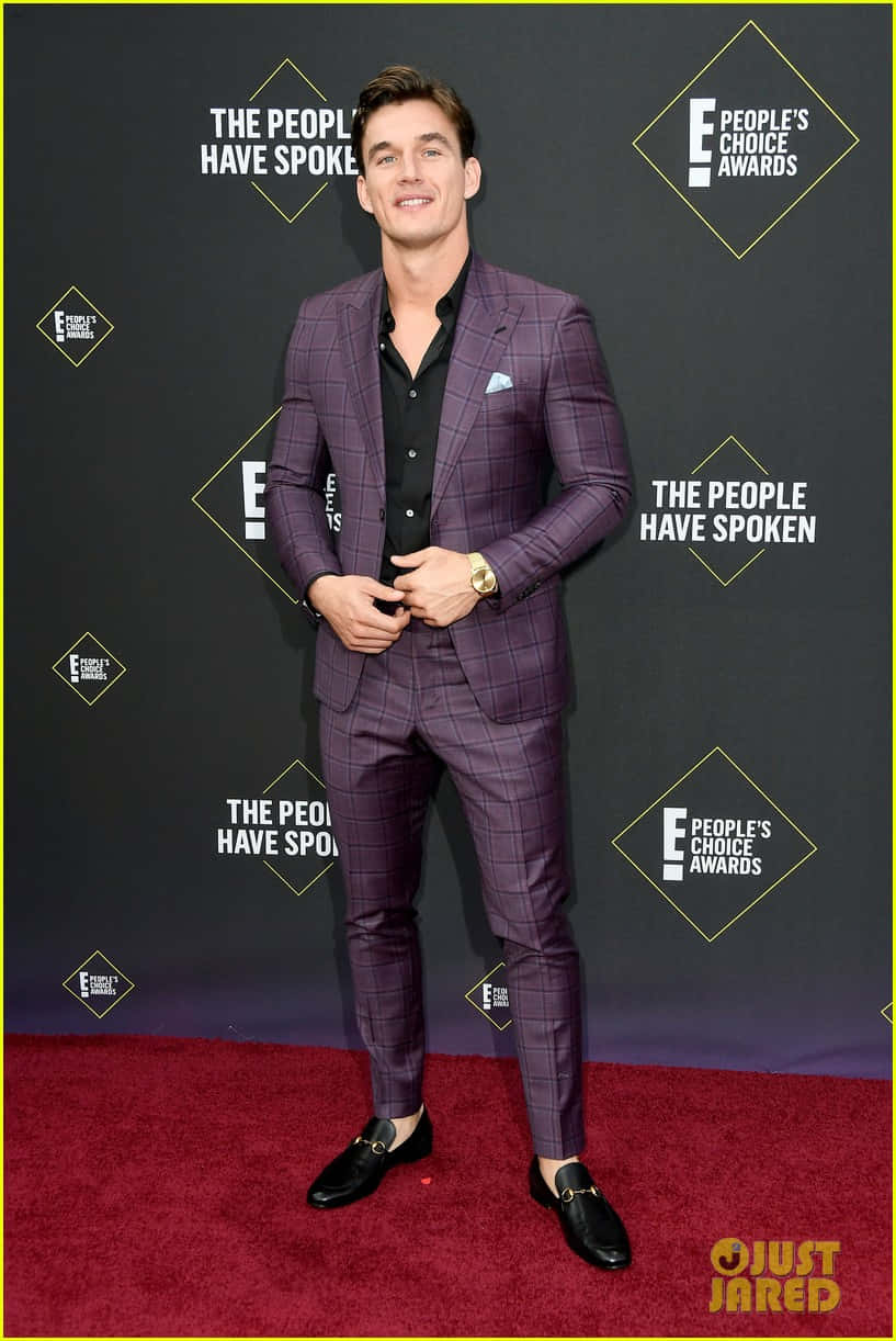 Purple Suit 桌布 壁紙 — 一位微笑的男子身穿紫色格紋西裝，自信地站在人民選擇獎的紅地毯上。