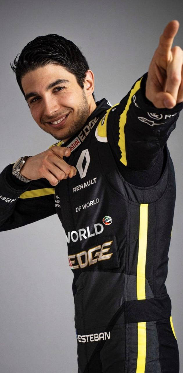 身穿雷諾賽車服的賽車手自信地指向觀看者。 — F1手機壁紙 壁紙