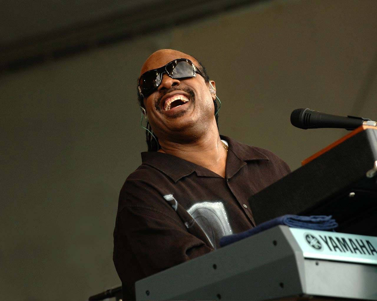 音樂 桌布 壁紙 — Snoop Dogg 在舞台上用Yamaha鍵盤和麥克風表演時開心地大笑。