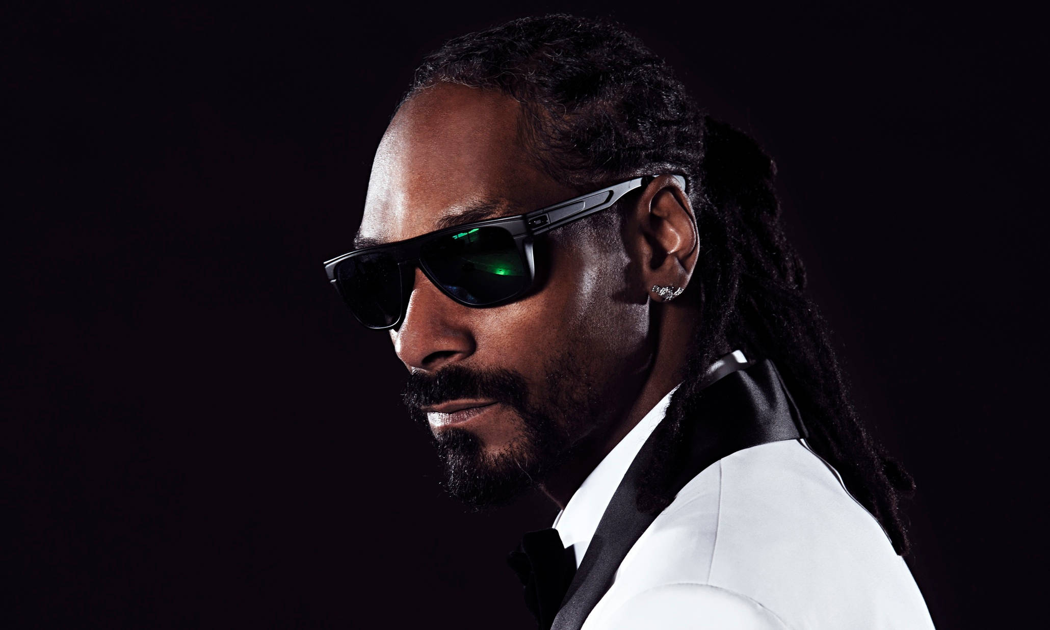 Snoop 桌布 壁紙 — Snoop Dogg 戴著時尚黑色太陽眼鏡和白色燕尾服，在深色背景上帶有綠色鏡片反射。