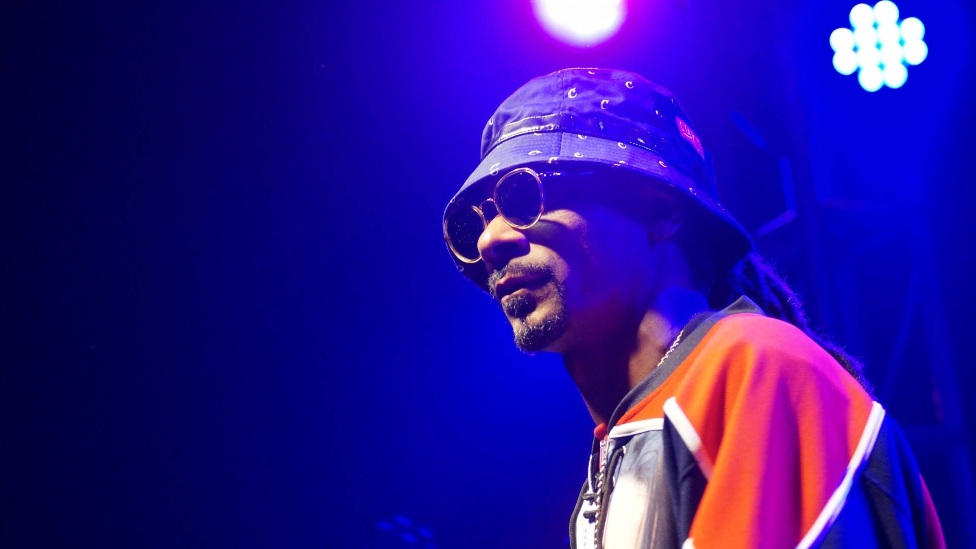 Snoop 桌布 壁紙 — Snoop Dogg 戴著漁夫帽和太陽眼鏡，在演唱會表演中被藍色舞台燈光籠罩。