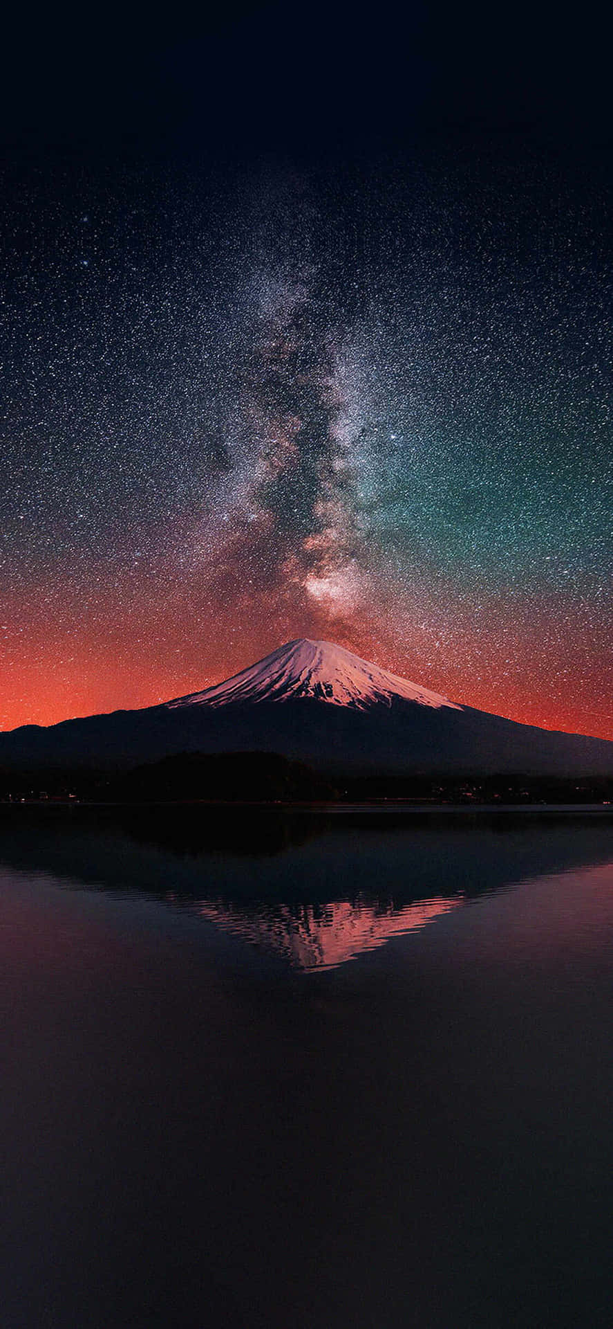  壁紙 — 白雪覆蓋的富士山在充滿活力的星空下倒映，銀河拱橋橫跨天際。