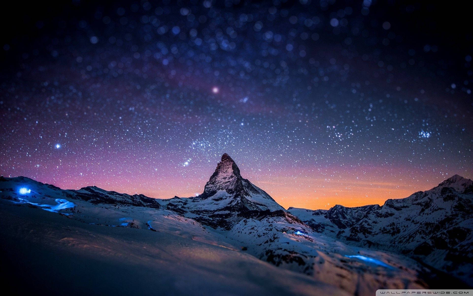 白雪覆蓋的山峰在紫色和橙色色調的星空暮色天空下。 — 山景 壁紙
