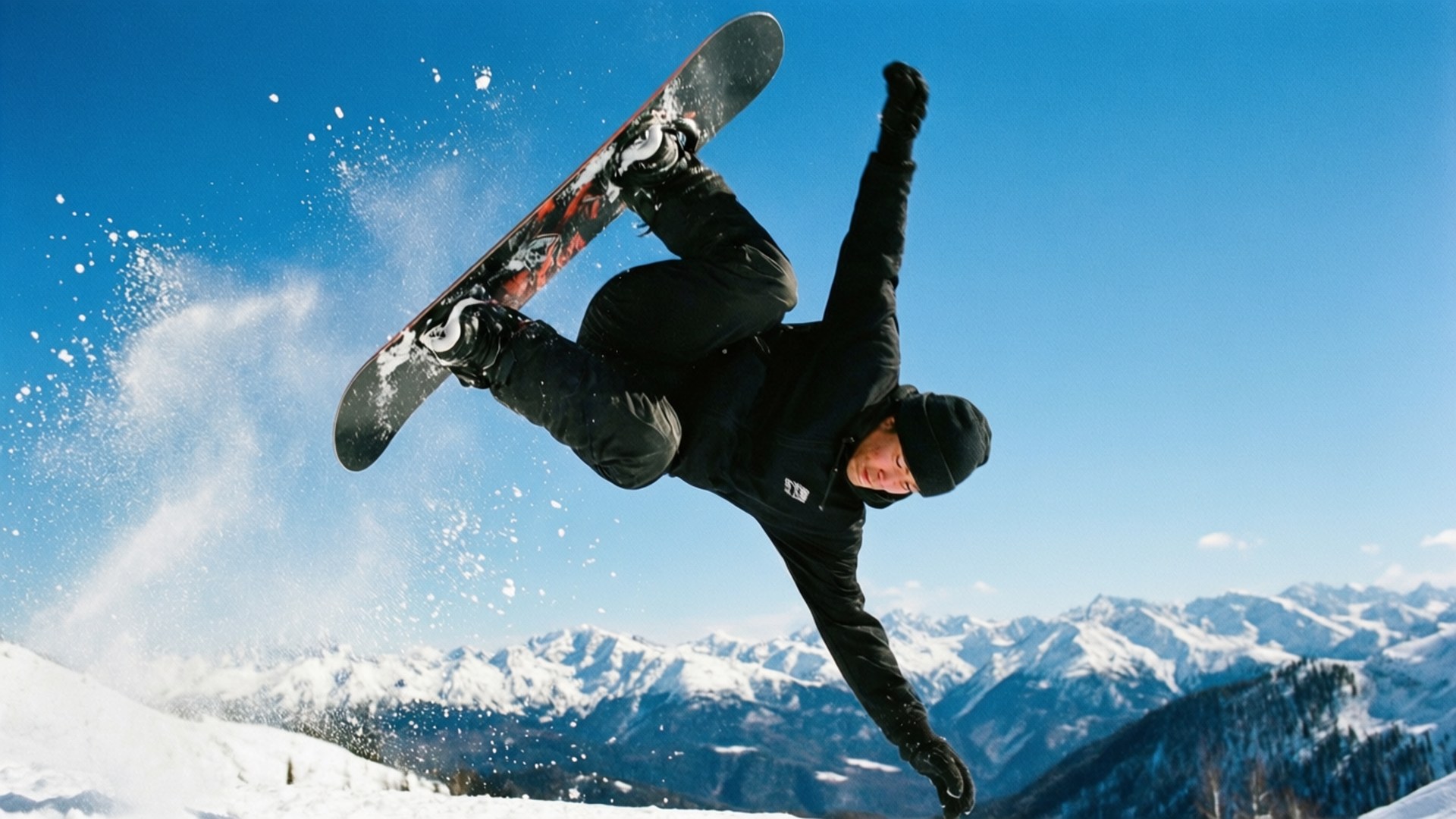 Backflip in Blue 壁紙 — 一名滑雪板運動員在半空中表演技巧，背景是白雪覆蓋的山脈和晴朗的藍天。