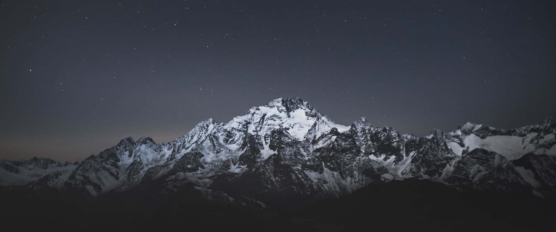 在繁星點點的夜空和微弱極光下的雪山山脈。 — 3440X1440 壁紙