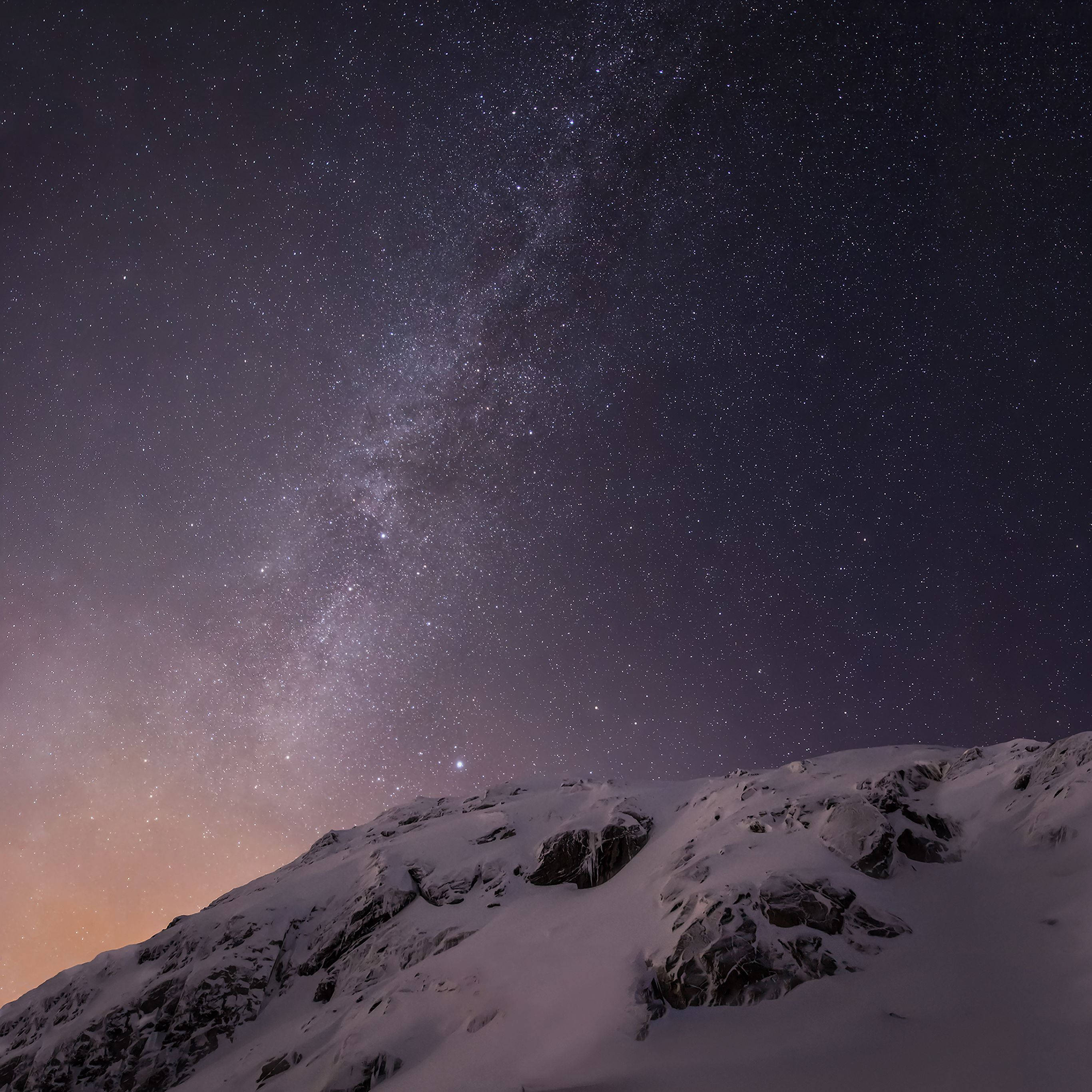 白雪覆蓋的山峰，在繁星點點的夜空下，銀河清晰可見。 — iPad 壁紙