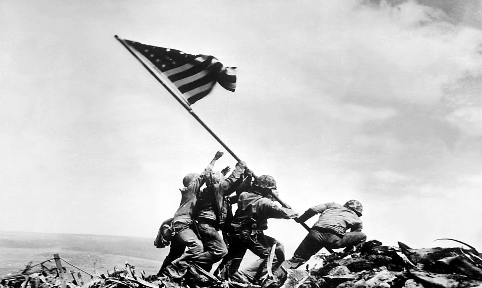 World War 桌布 壁紙 — 士兵在歷史黑白照片中於戰場山脊上舉起美國國旗。